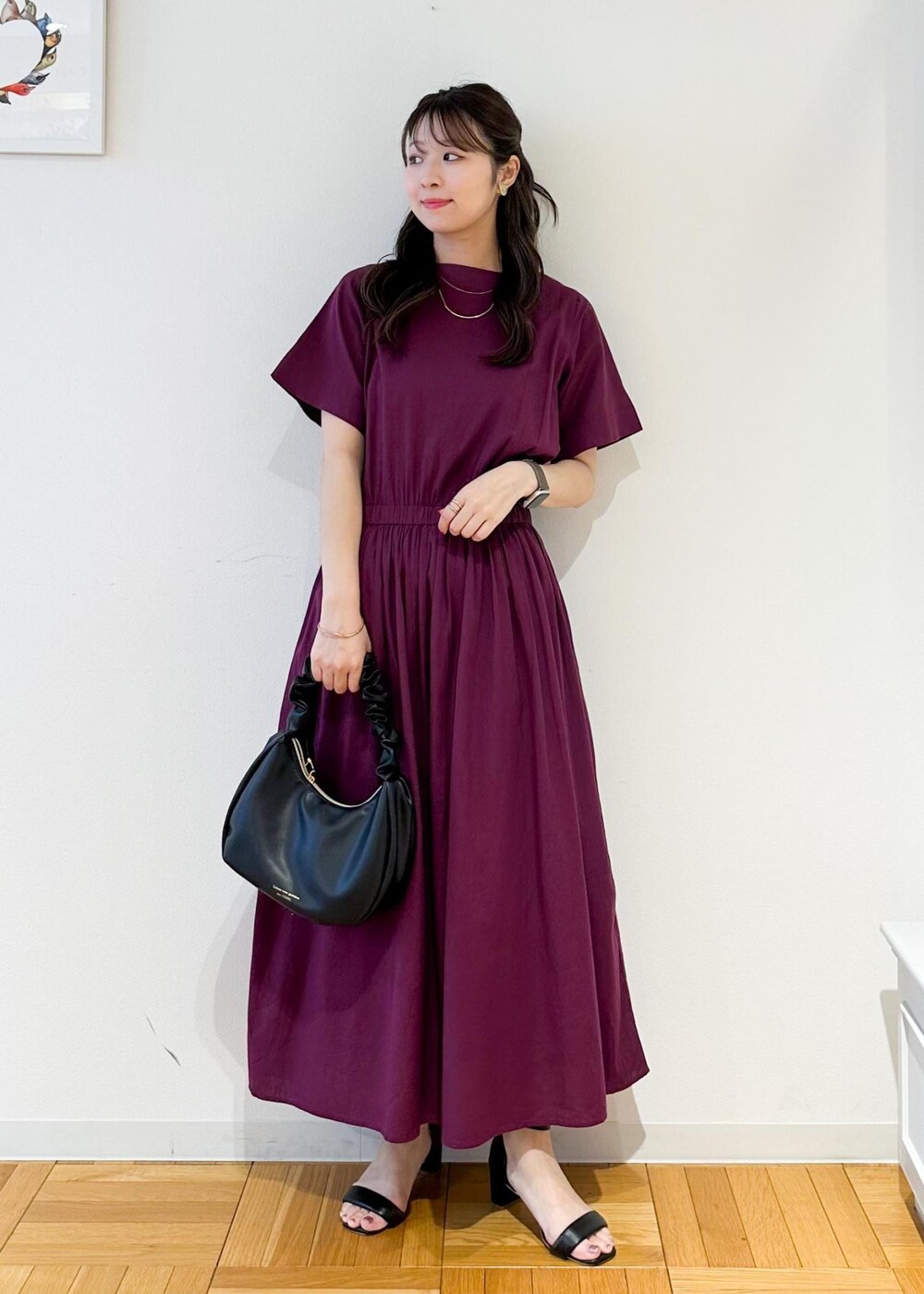 ブラック系のハンドバッグ、レッド系のワンピースを着用したレディースの夏コーディネートの2枚目の写真