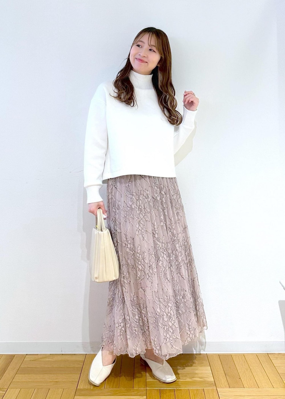 ホワイト系のハンドバッグ、ピンク系のスカート、ホワイト系のニット/セーターを着用したレディースの春コーディネートの2枚目の写真