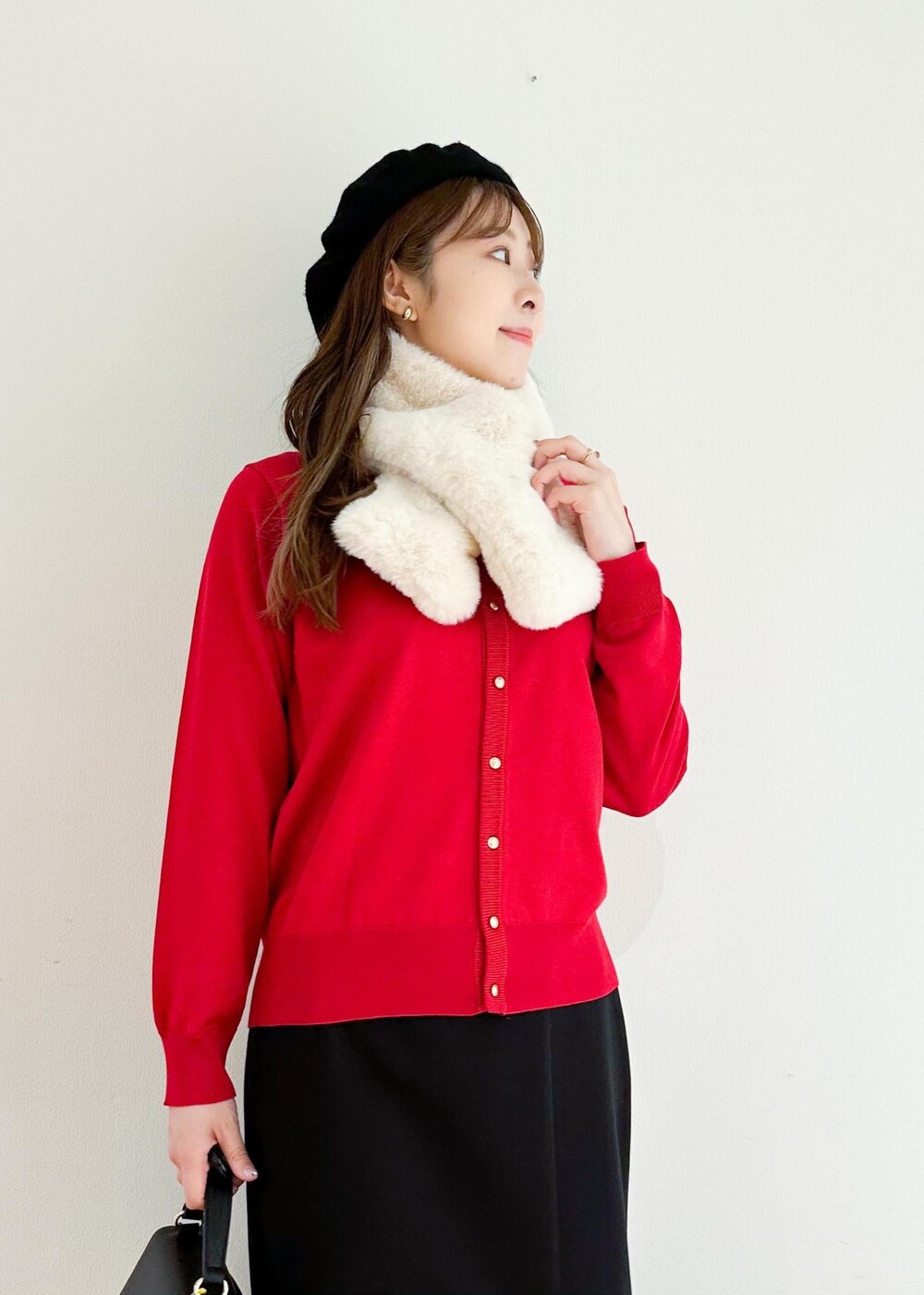 レッド系のカーディガン/ボレロ、ブラック系のショルダーバッグ、ブラック系のスカートを着用したレディースの冬コーディネートの4枚目の写真