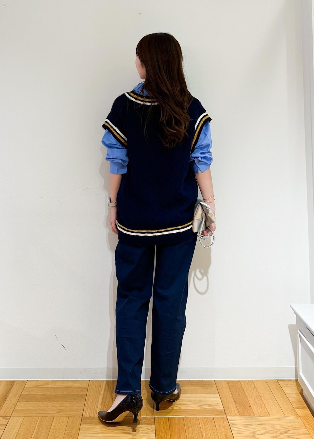 シルバー系のトートバッグ、ブルー系のベスト、ブルー系のシャツ/ブラウスを着用したレディースの夏コーディネートの3枚目の写真