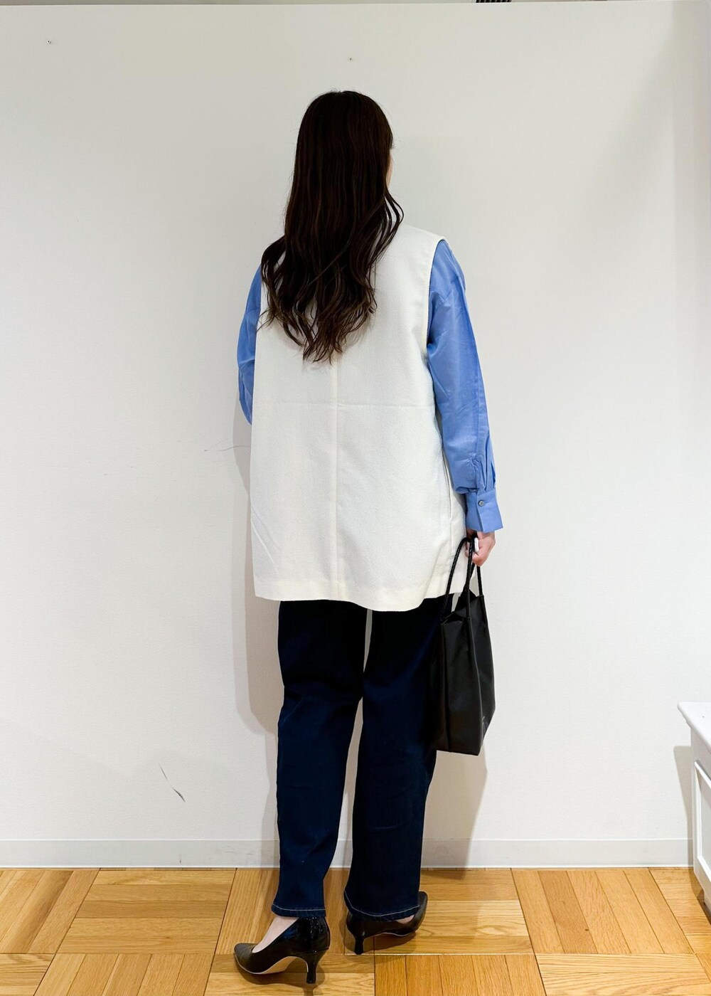 ブラック系のトートバッグ、ホワイト系のベスト、ブルー系のシャツ/ブラウスを着用したレディースの夏コーディネートの4枚目の写真