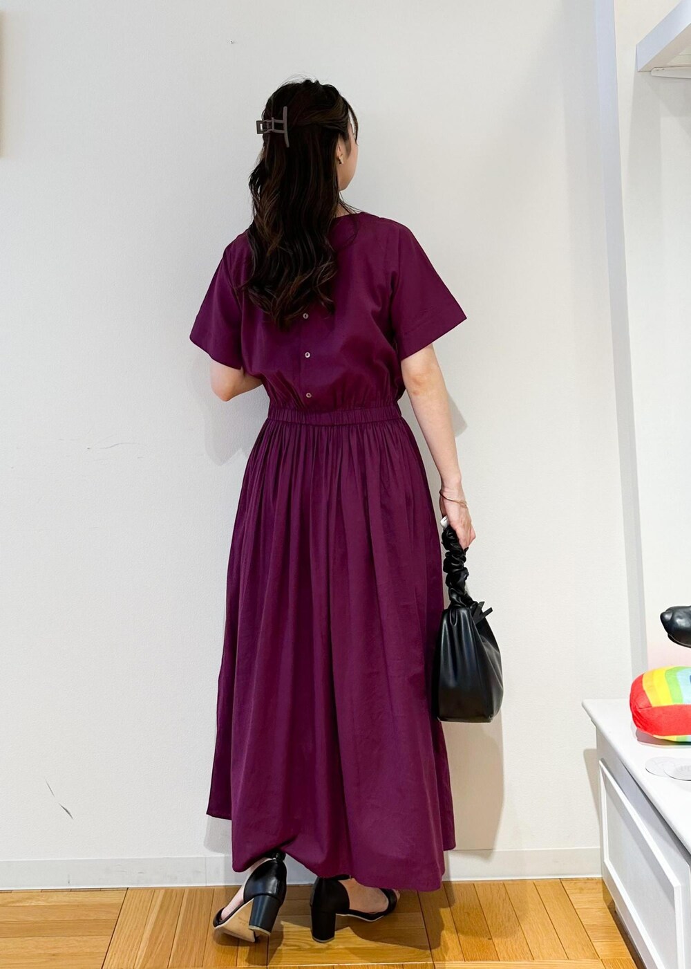 ブラック系のハンドバッグ、レッド系のワンピースを着用したレディースの夏コーディネートの3枚目の写真