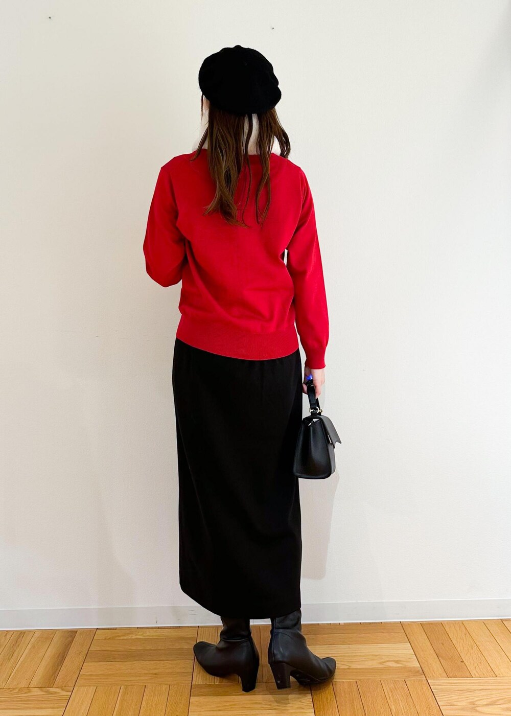 レッド系のカーディガン/ボレロ、ブラック系のショルダーバッグ、ブラック系のスカートを着用したレディースの冬コーディネートの3枚目の写真