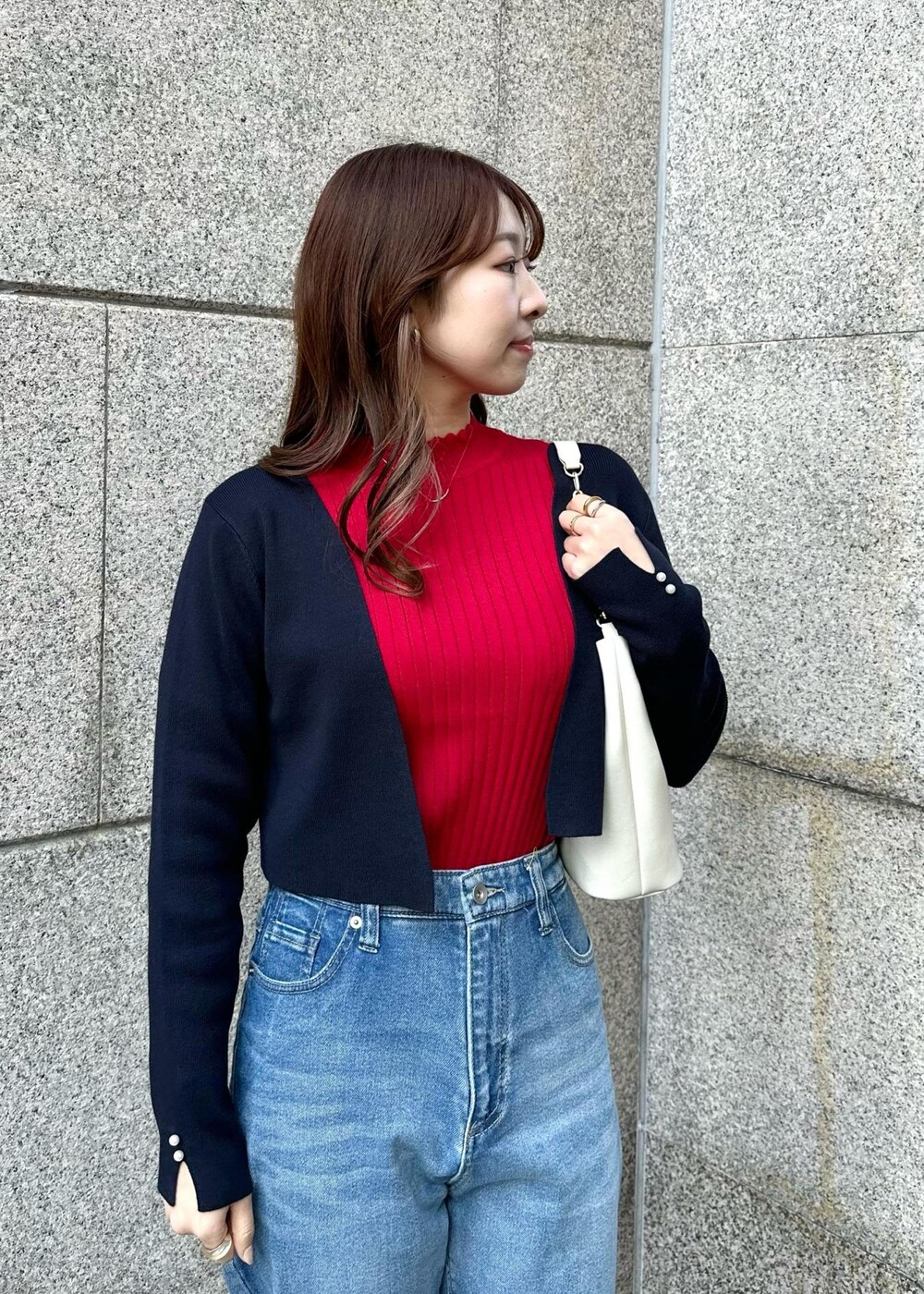 レッド系のニット/セーター、ブルー系のデニムパンツ、ブルー系のカーディガン/ボレロを着用したレディースの冬コーディネートの4枚目の写真