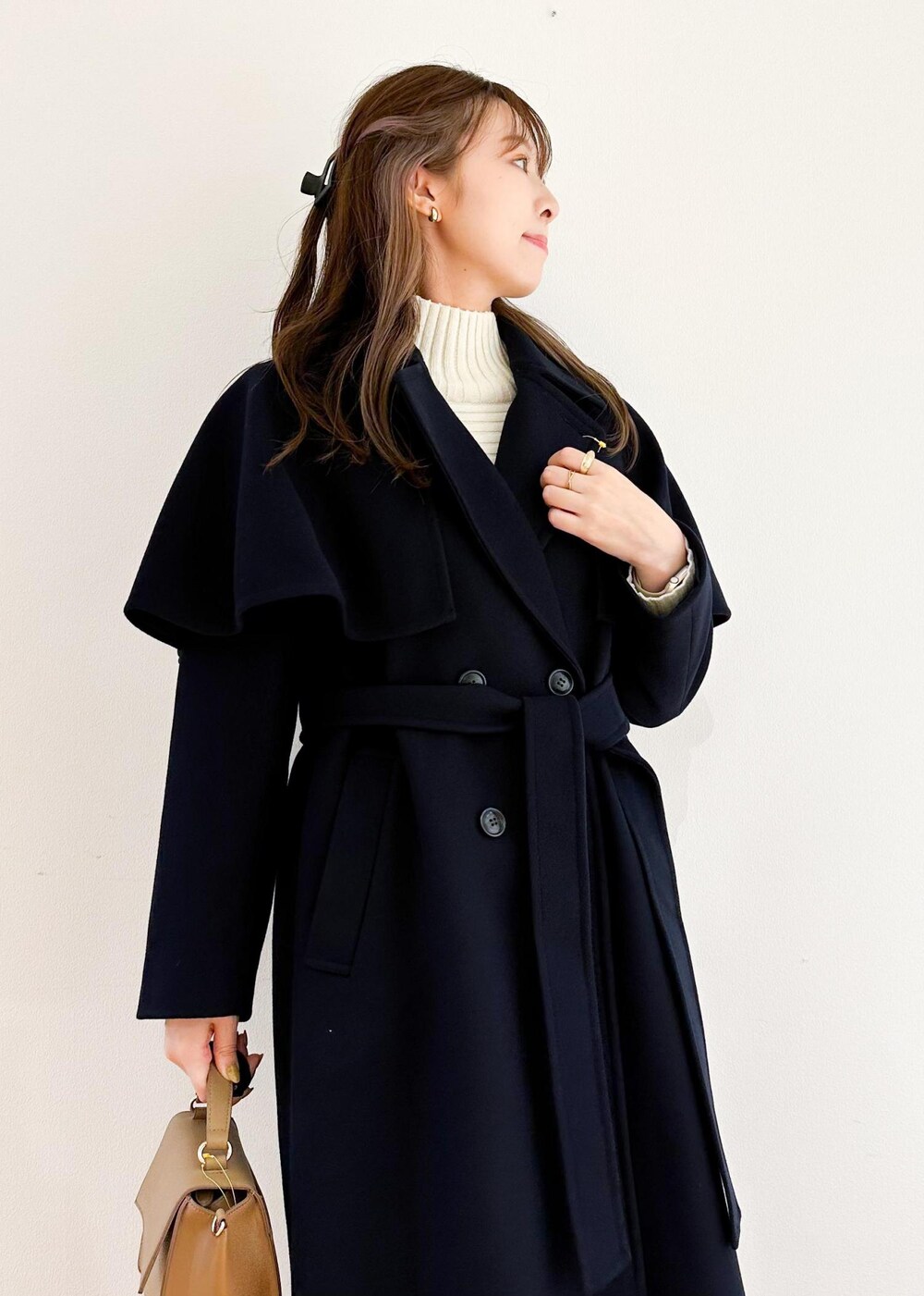 ホワイト系のニット/セーター、ブラウン系のショルダーバッグ、ブラック系のスカートを着用したレディースの秋コーディネートの4枚目の写真