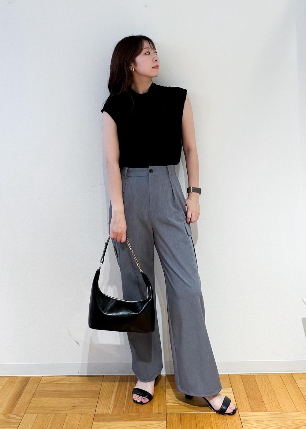 ブラック系のショルダーバッグ、グレー系のカーゴパンツ、ブラック系のニット/セーターを着用したレディースの夏コーディネートの2枚目の写真