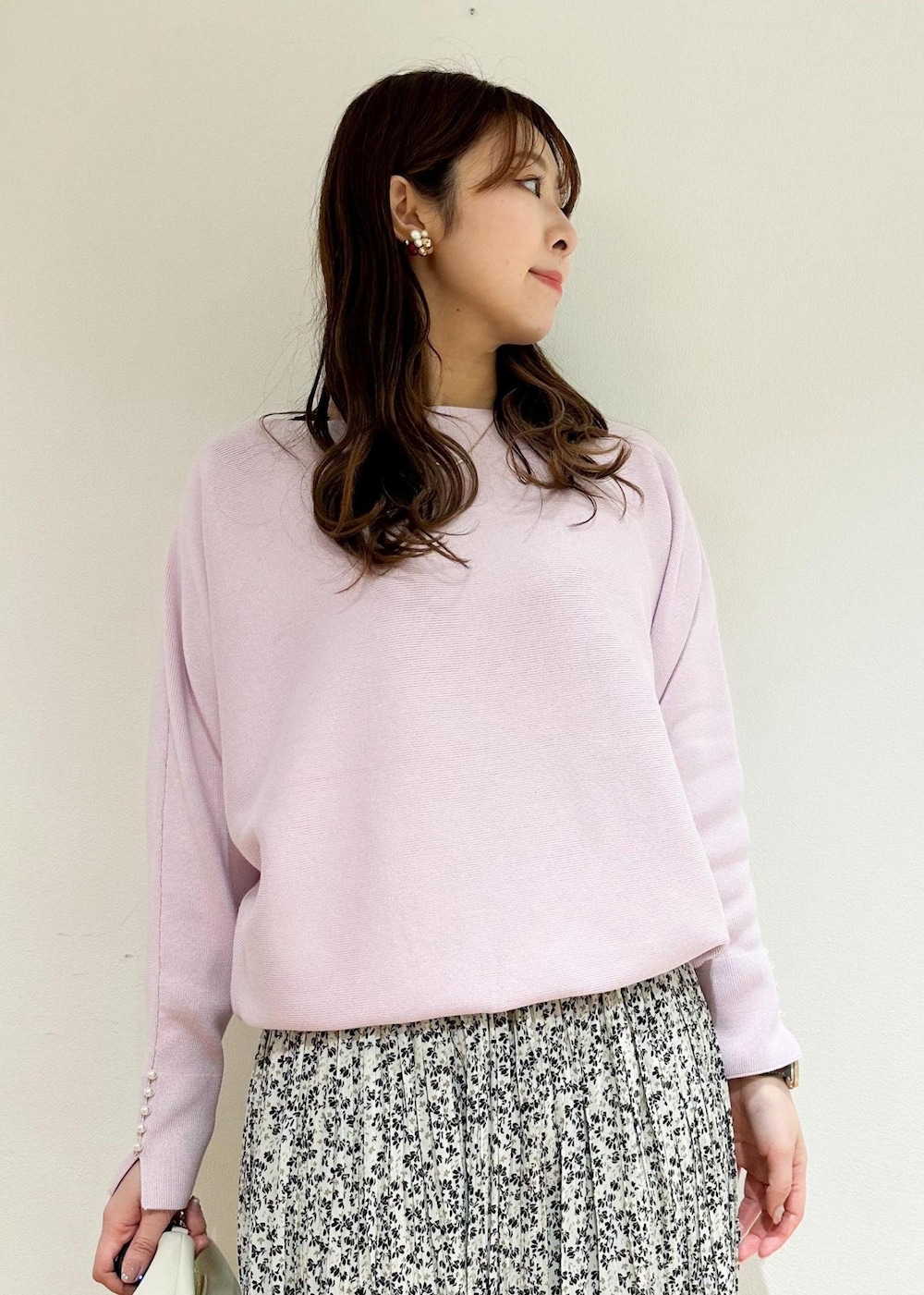 ベージュ系のスカート、ホワイト系のショルダーバッグ、ピンク系のニット/セーターを着用したレディースの冬コーディネートの3枚目の写真