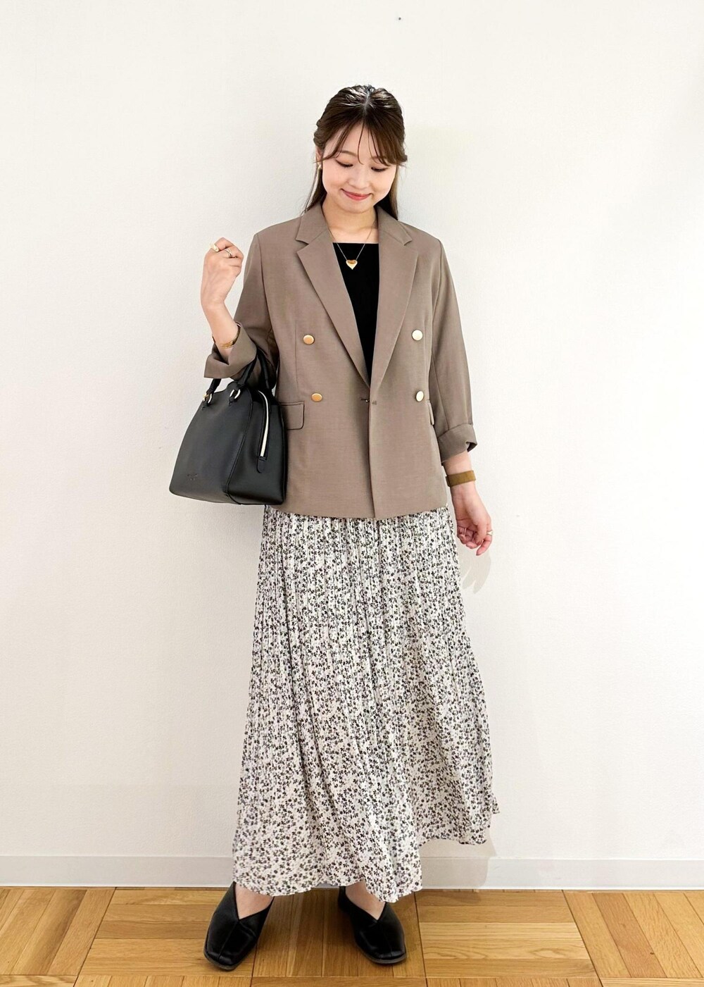 ベージュ系のスカート、ホワイト系のボストンバッグ、ブラウン系のテーラードジャケットを着用したレディースの夏コーディネートの2枚目の写真