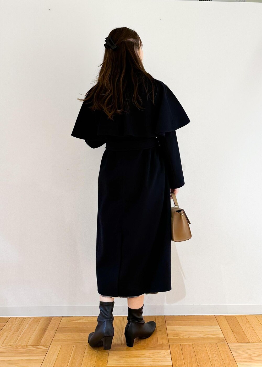 ホワイト系のニット/セーター、ブラウン系のショルダーバッグ、ブラック系のスカートを着用したレディースの秋コーディネートの3枚目の写真