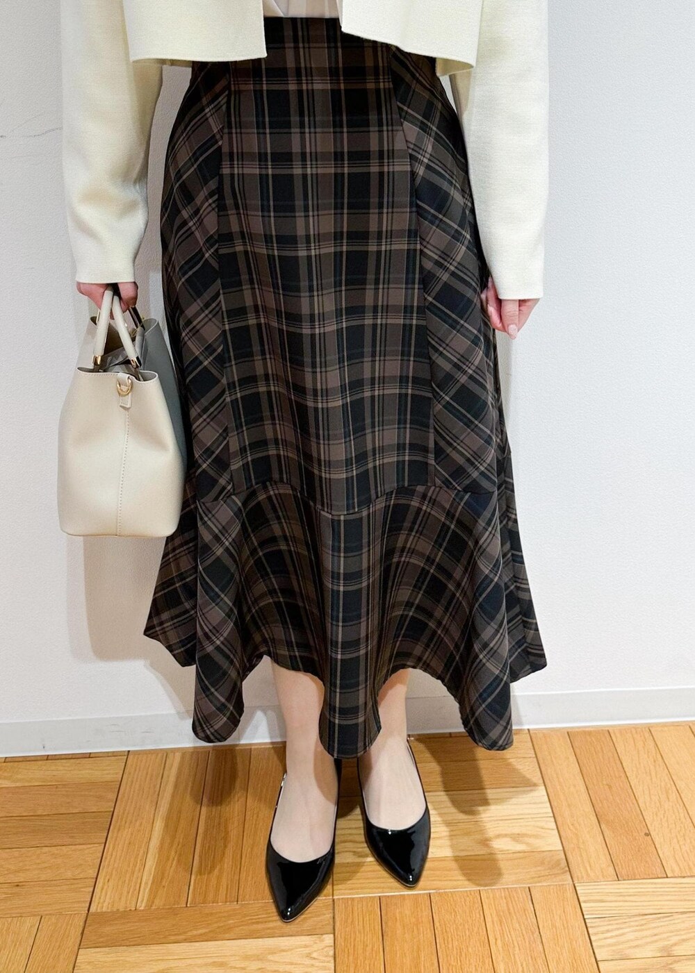 イエロー系のスカート、ベージュ系のシャツ/ブラウス、ホワイト系のカーディガン/ボレロを着用したレディースの冬コーディネートの7枚目の写真