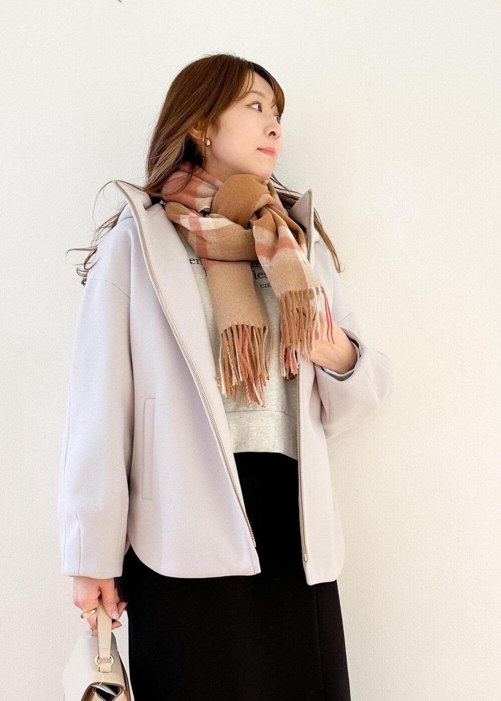 グレー系のその他アウター、ホワイト系のショルダーバッグ、ブラック系のスカートを着用したレディースの冬コーディネートの4枚目の写真