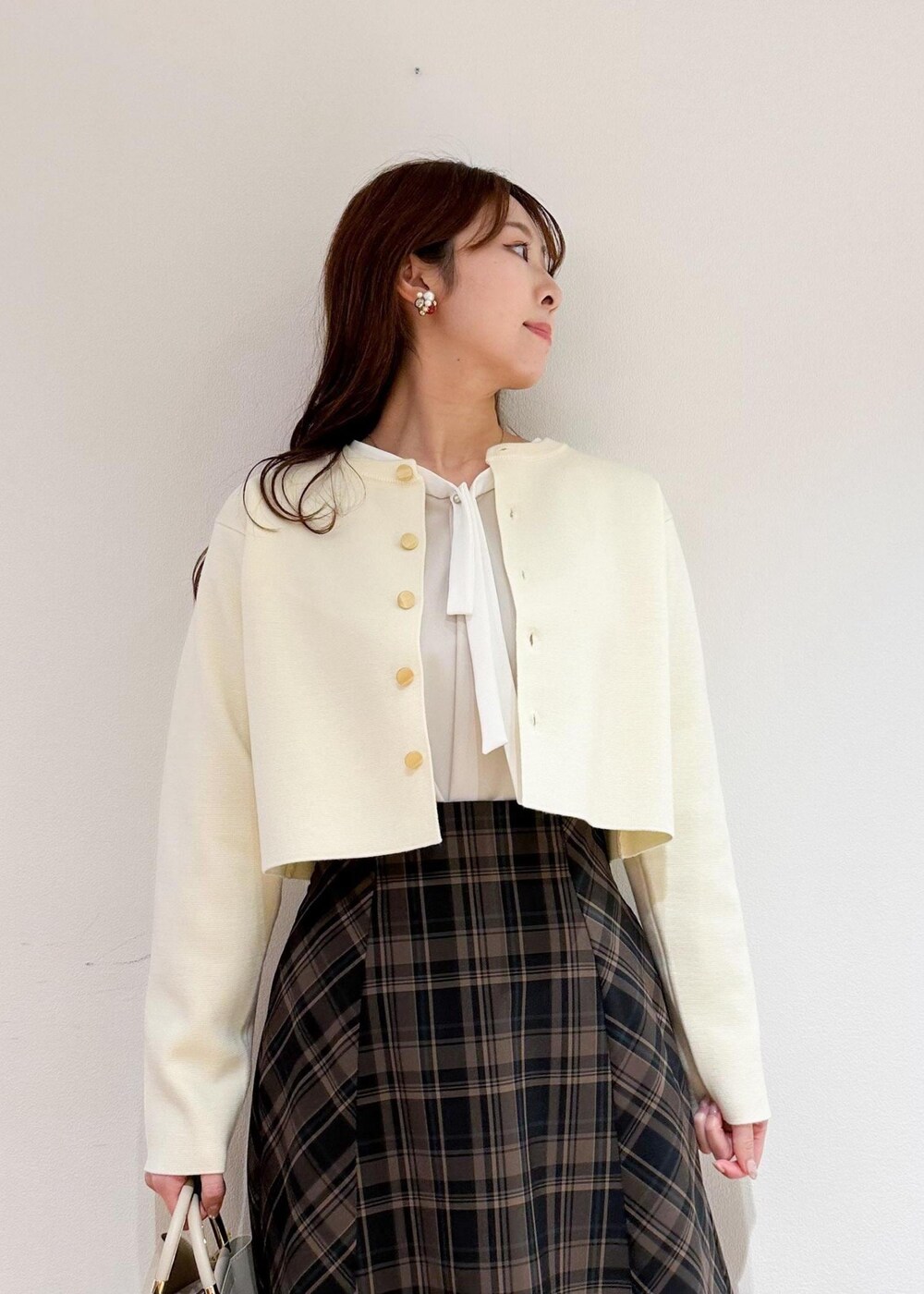 イエロー系のスカート、ベージュ系のシャツ/ブラウス、ホワイト系のカーディガン/ボレロを着用したレディースの冬コーディネートの5枚目の写真