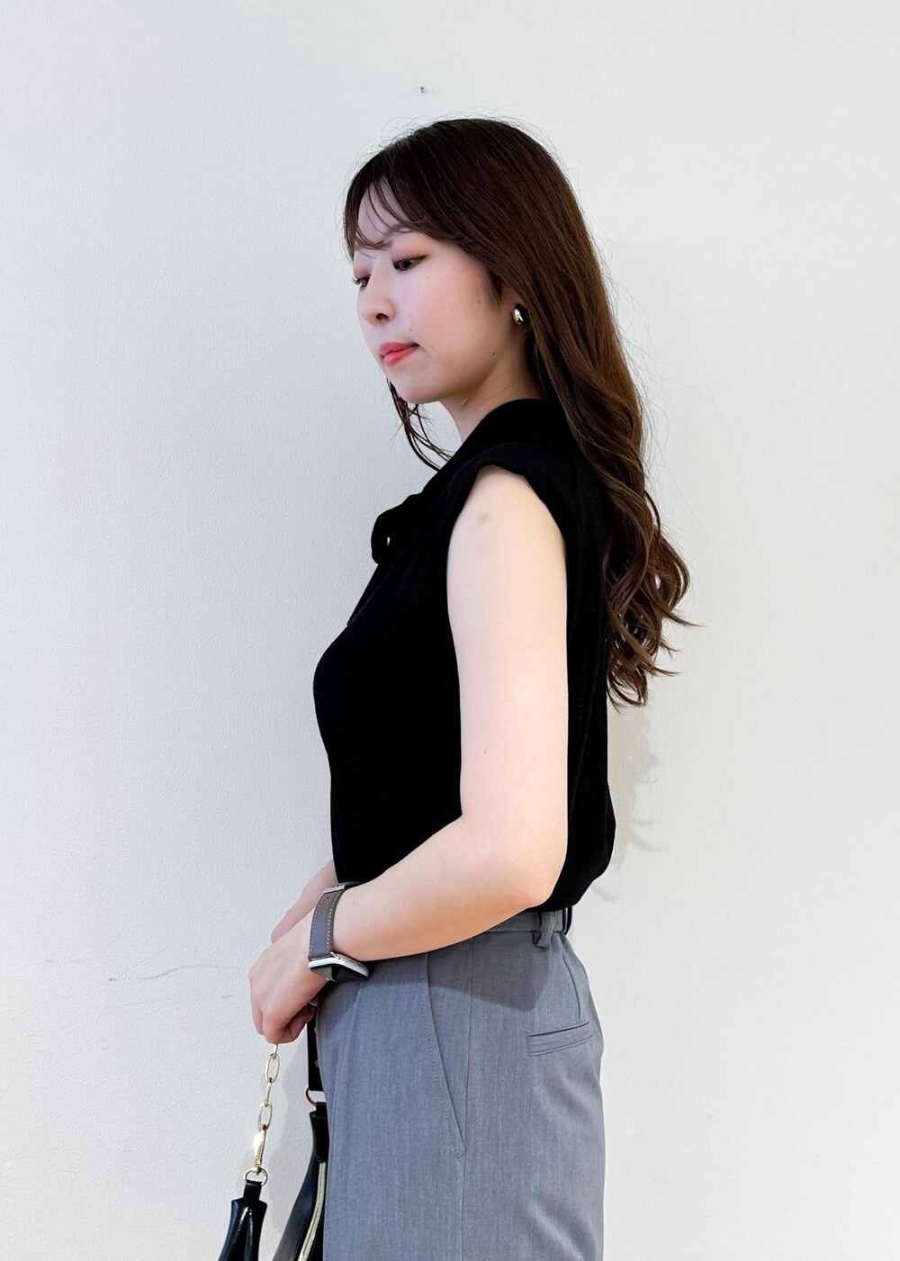 ブラック系のショルダーバッグ、グレー系のカーゴパンツ、ブラック系のニット/セーターを着用したレディースの夏コーディネートの5枚目の写真