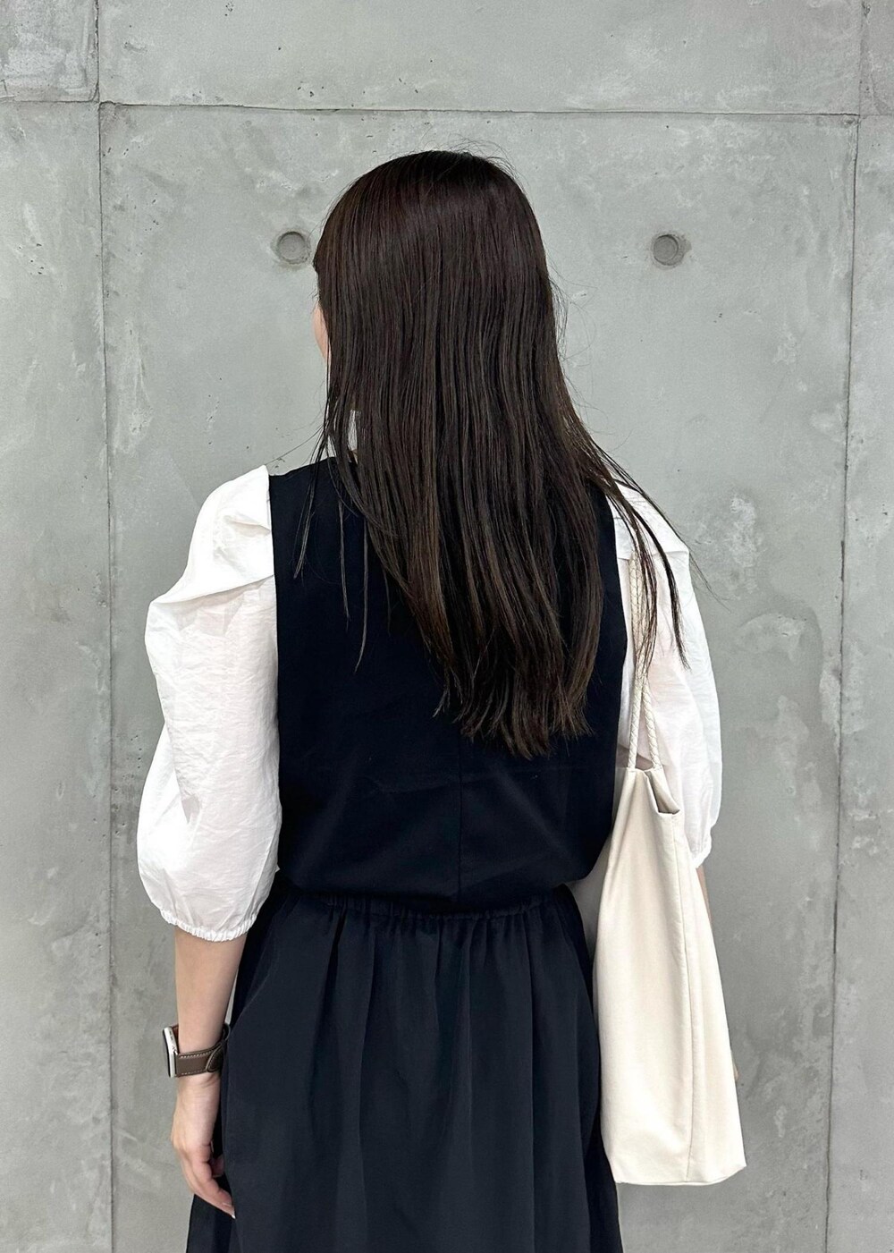 ホワイト系のトートバッグ、ブラック系のスカート、ブラック系のTシャツ/カットソーを着用したレディースの夏コーディネートの5枚目の写真