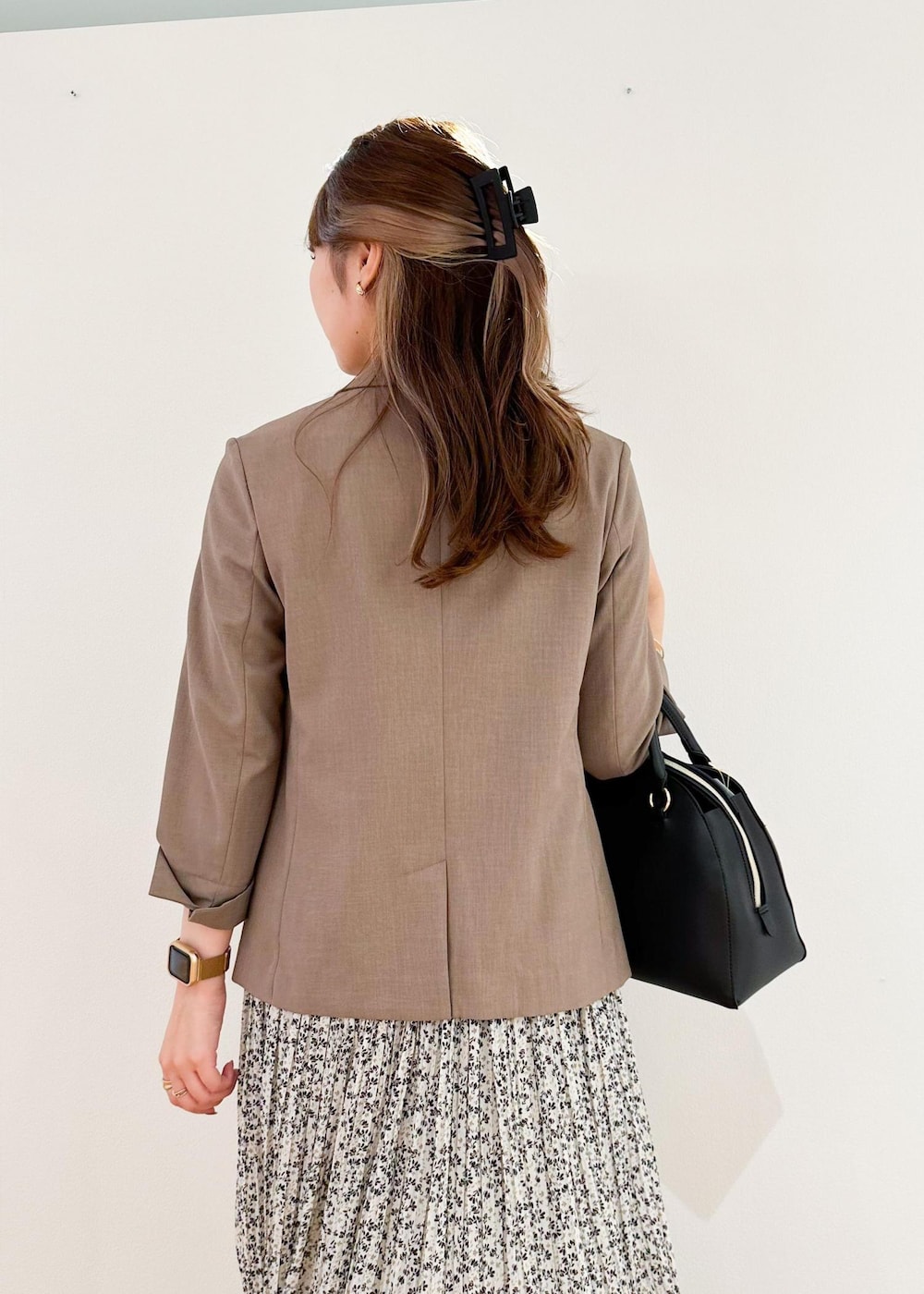 ベージュ系のスカート、ホワイト系のボストンバッグ、ブラウン系のテーラードジャケットを着用したレディースの夏コーディネートの5枚目の写真