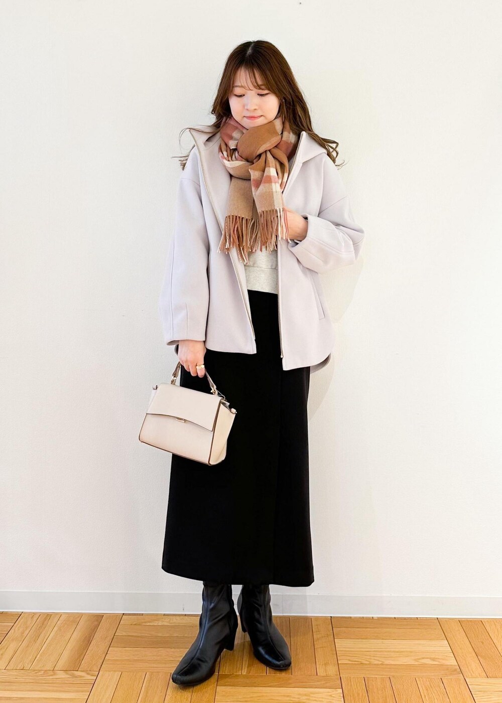 グレー系のその他アウター、ホワイト系のショルダーバッグ、ブラック系のスカートを着用したレディースの冬コーディネートの2枚目の写真