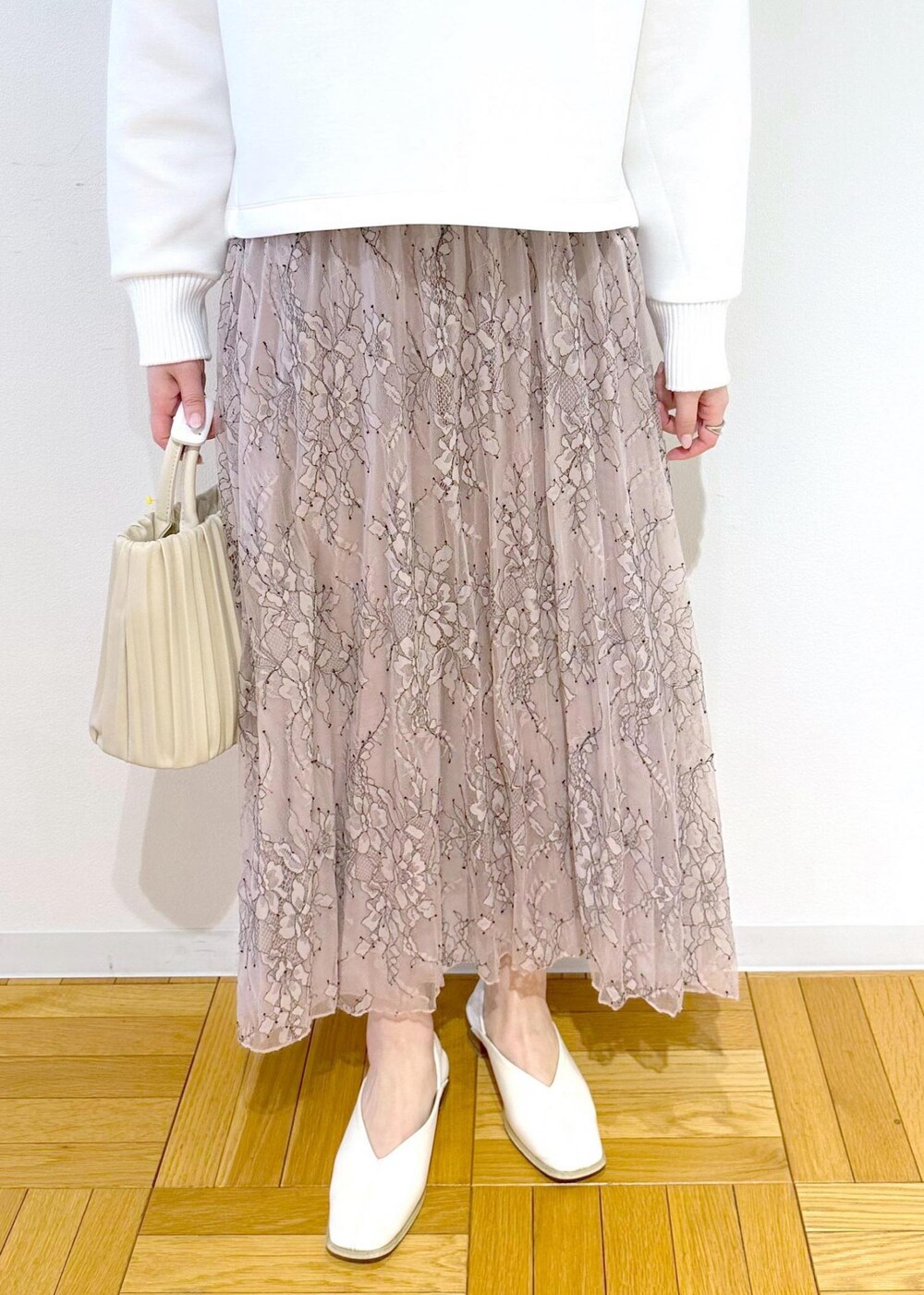 ホワイト系のハンドバッグ、ピンク系のスカート、ホワイト系のニット/セーターを着用したレディースの春コーディネートの6枚目の写真