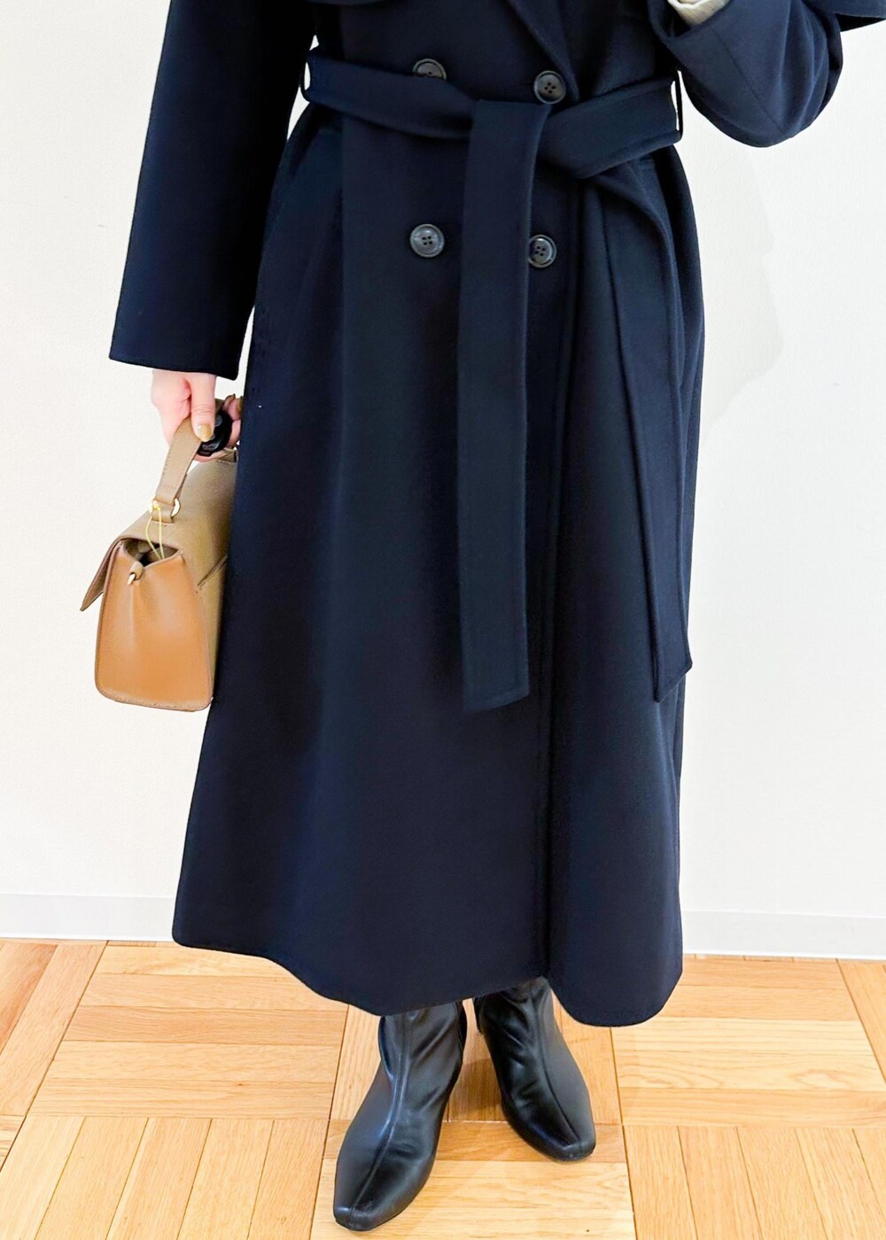 ホワイト系のニット/セーター、ブラウン系のショルダーバッグ、ブラック系のスカートを着用したレディースの秋コーディネートの7枚目の写真