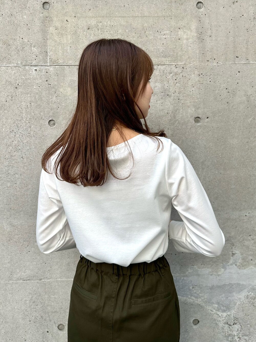 ホワイト系のTシャツ/カットソー、グリーン系のスカート、ブラック系のショルダーバッグを着用したレディースの春コーディネートの4枚目の写真