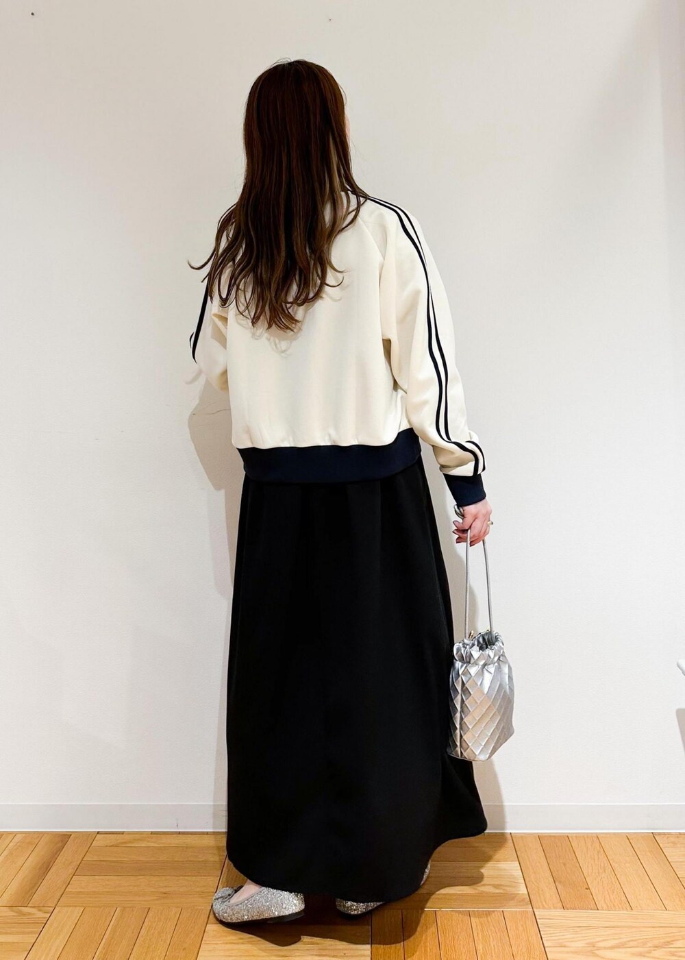 ブラック系のワンピース、グレー系のニット/セーター、シルバー系のショルダーバッグを着用したレディースの冬コーディネートの3枚目の写真