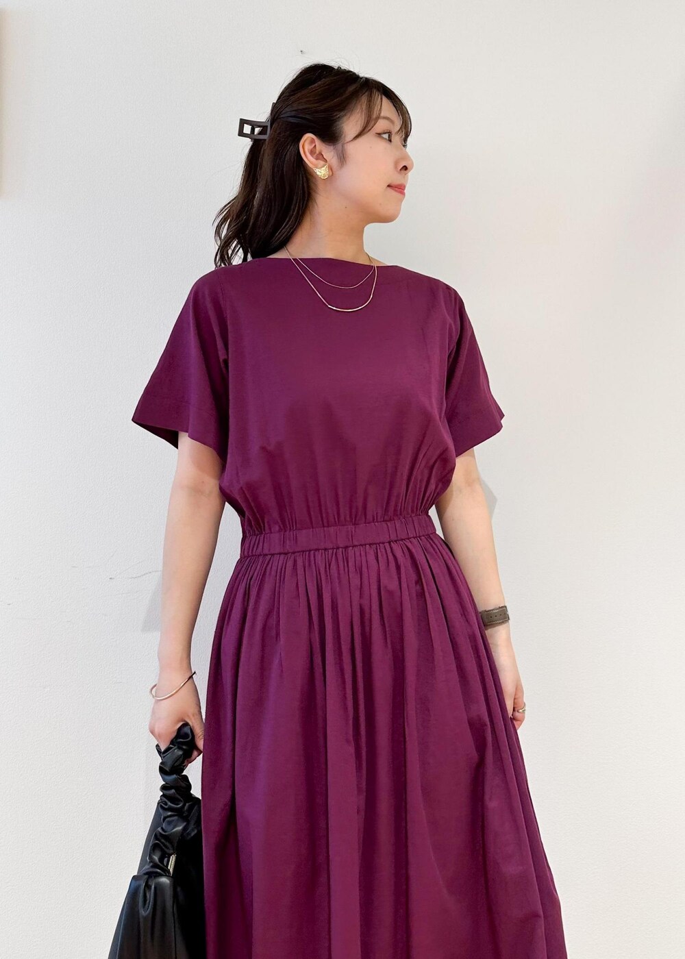 ブラック系のハンドバッグ、レッド系のワンピースを着用したレディースの夏コーディネートの4枚目の写真