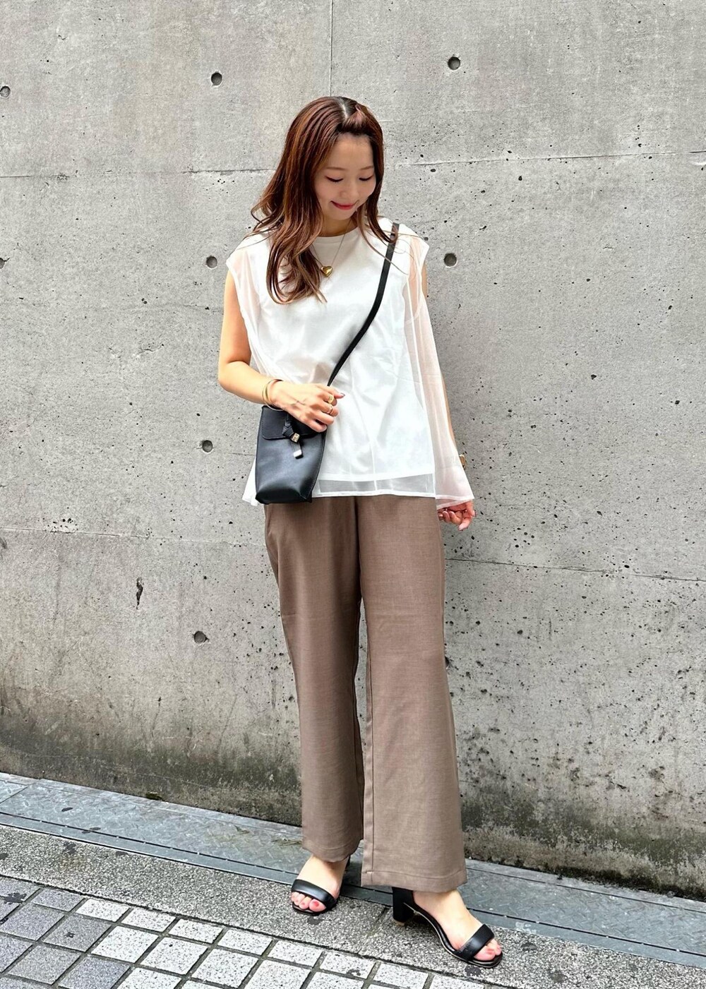 ブラック系のショルダーバッグ、ブラウン系のその他パンツ、ホワイト系のTシャツ/カットソーを着用したレディースの夏コーディネートの2枚目の写真