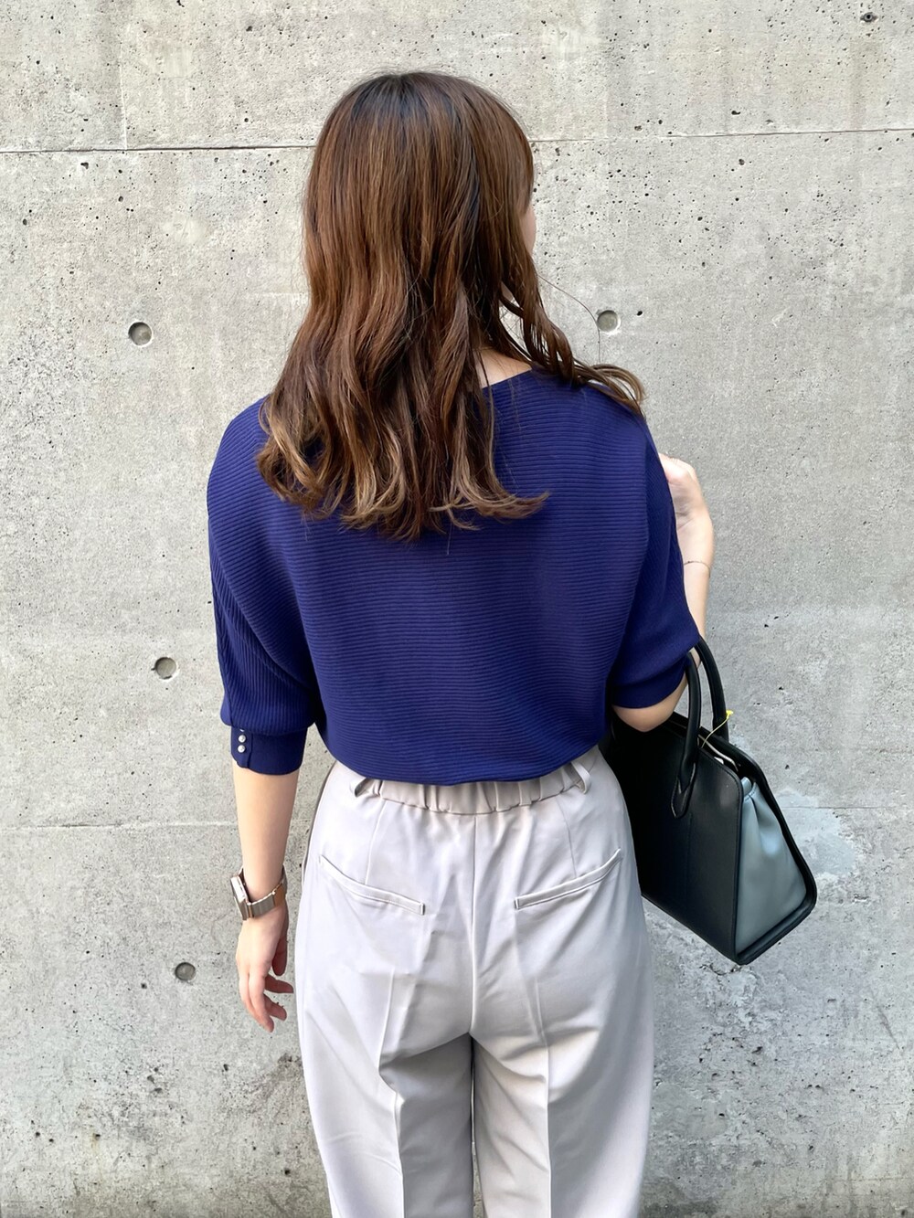 パープル系のニット/セーター、グレー系のその他パンツ、ブラック系のショルダーバッグを着用したレディースの秋コーディネートの4枚目の写真