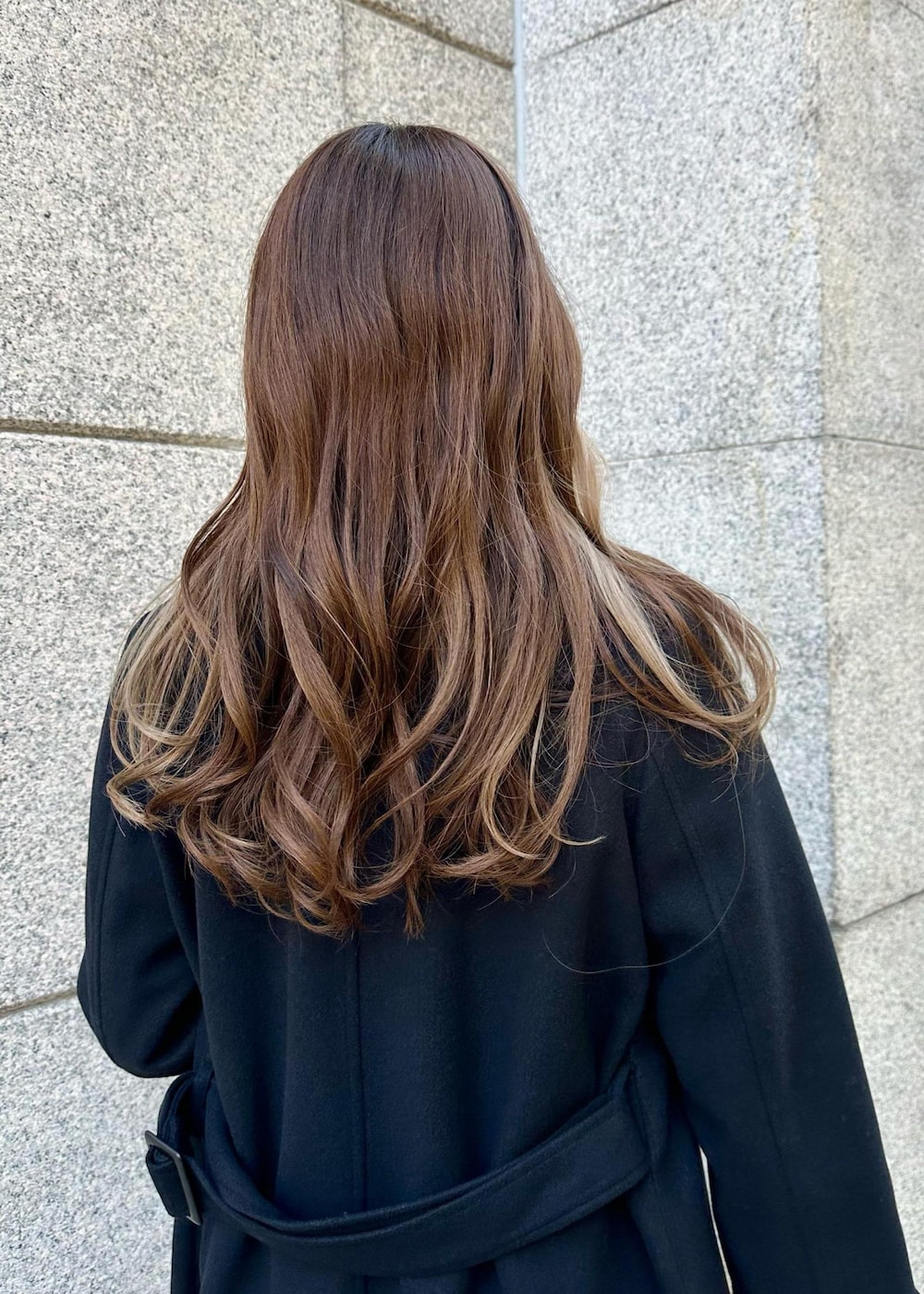 ブラウン系のショルダーバッグ、ブラック系のその他アウター、ホワイト系のスカートを着用したレディースの冬コーディネートの5枚目の写真