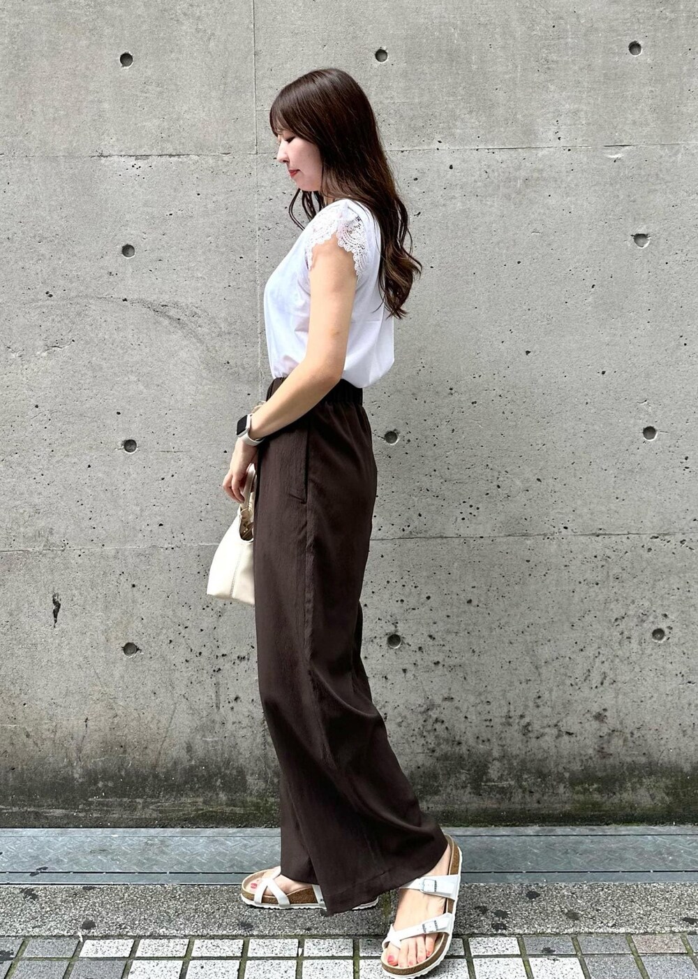 ホワイト系のショルダーバッグ、ホワイト系のTシャツ/カットソー、ブラウン系のその他パンツを着用したレディースの秋コーディネートの3枚目の写真