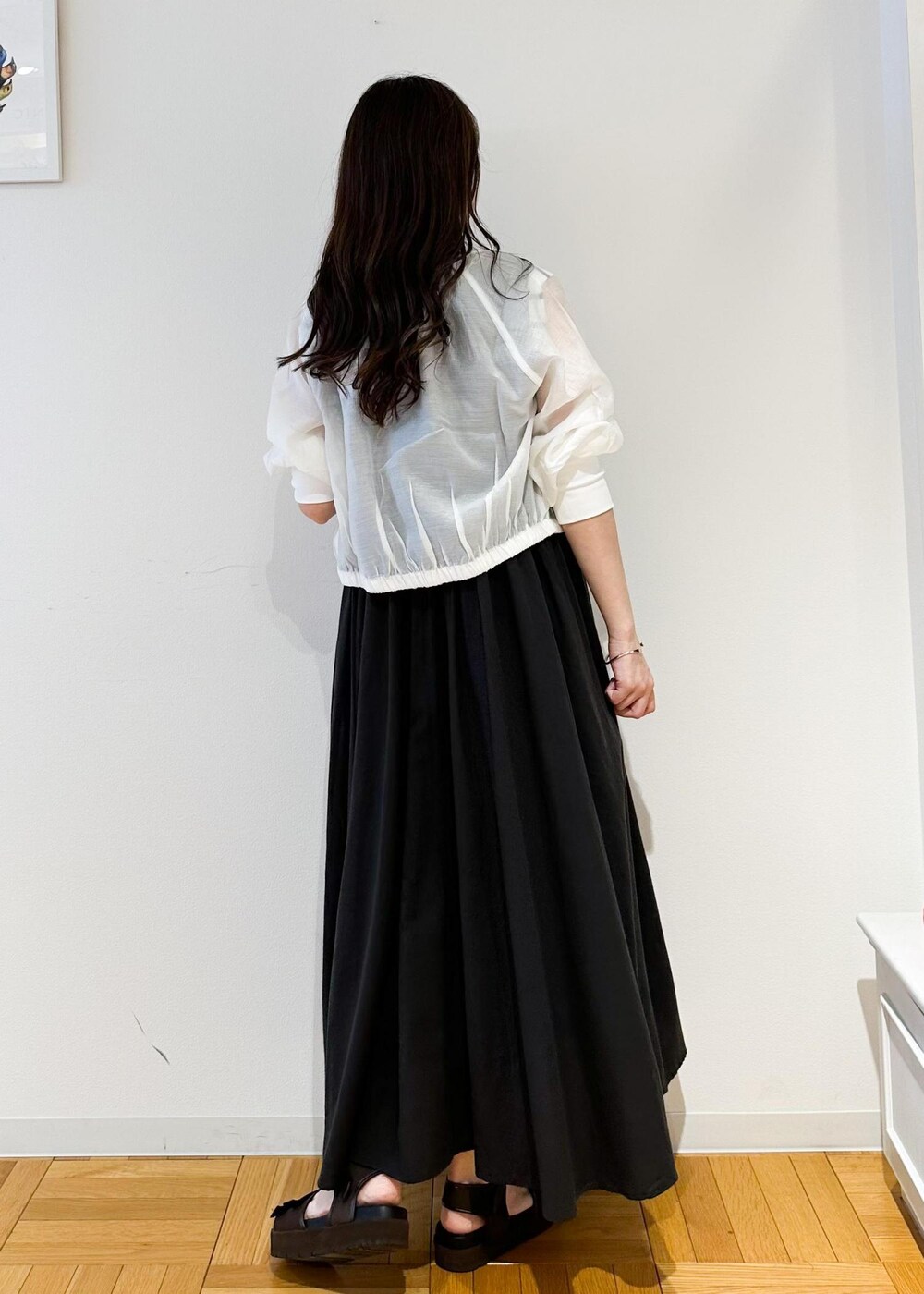 シルバー系のショルダーバッグ、ホワイト系のニット/セーター、ホワイト系のブルゾンを着用したレディースの夏コーディネートの3枚目の写真