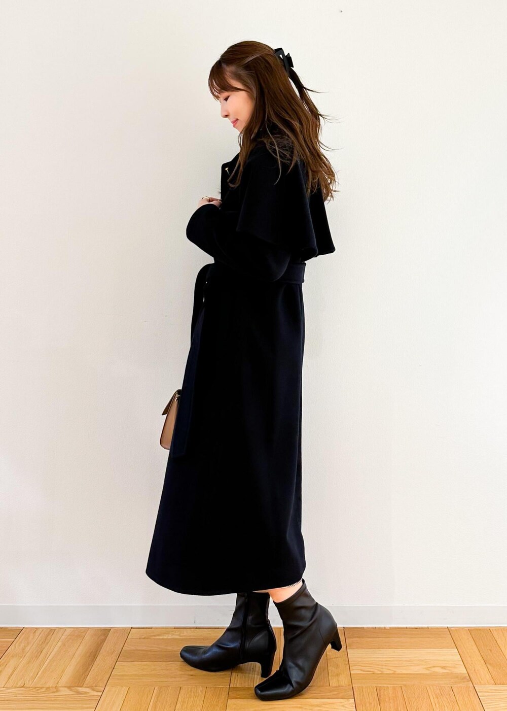 ホワイト系のニット/セーター、ブラウン系のショルダーバッグ、ブラック系のスカートを着用したレディースの秋コーディネートの2枚目の写真