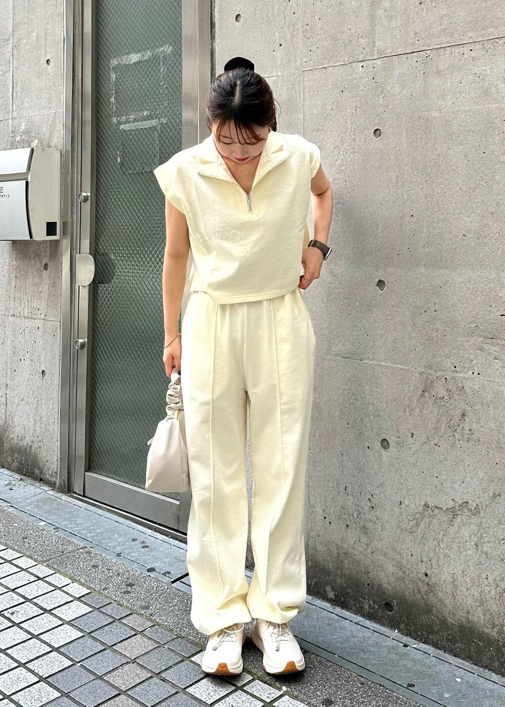 ホワイト系のTシャツ/カットソー、ホワイト系のスウェットパンツ、ホワイト系のハンドバッグを着用したレディースの春コーディネートの3枚目の写真
