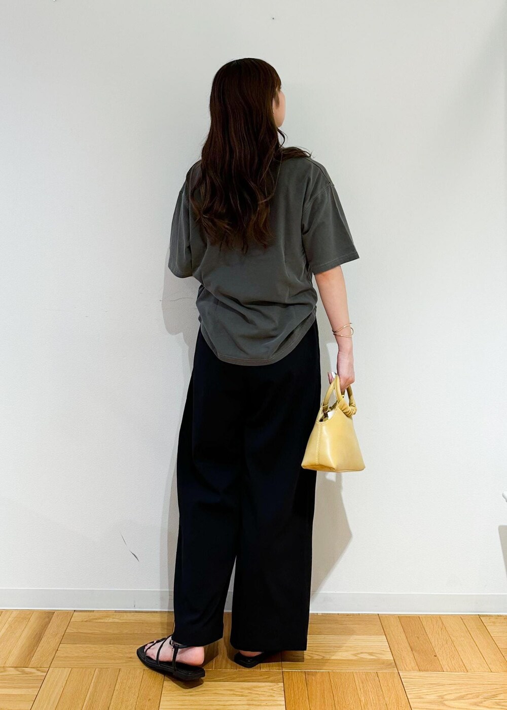 イエロー系のショルダーバッグ、グレー系のTシャツ/カットソー、ブラック系のその他パンツを着用したレディースの秋コーディネートの4枚目の写真