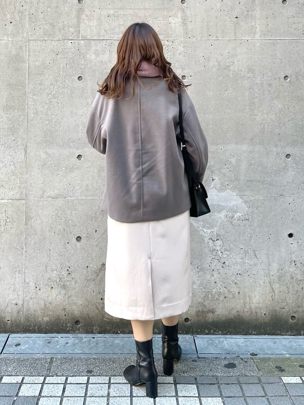 グレー系のその他アウター、ベージュ系のジャンパースカート、ブラック系のショルダーバッグを着用したレディースの秋コーディネートの2枚目の写真