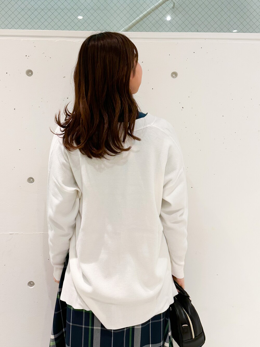 ホワイト系のカーディガン/ボレロ、グリーン系のニット/セーター、ホワイト系のスカートを着用したレディースの冬コーディネートの4枚目の写真