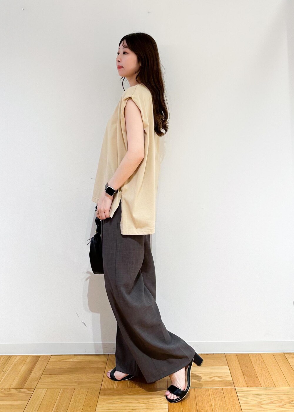 ベージュ系のTシャツ/カットソー、ブラウン系のその他パンツ、ブラック系のハンドバッグを着用したレディースの夏コーディネートの3枚目の写真