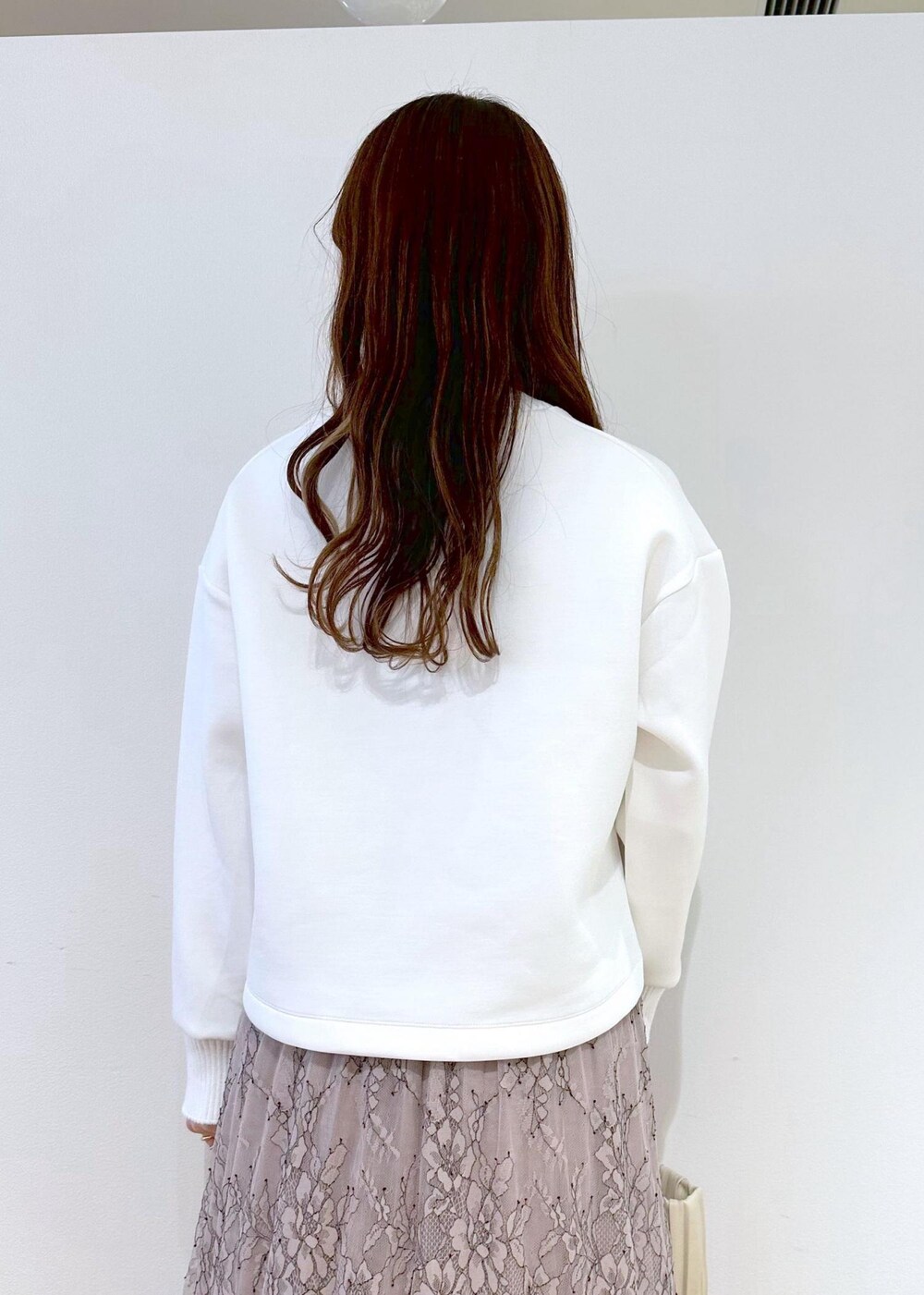 ホワイト系のハンドバッグ、ピンク系のスカート、ホワイト系のニット/セーターを着用したレディースの春コーディネートの5枚目の写真