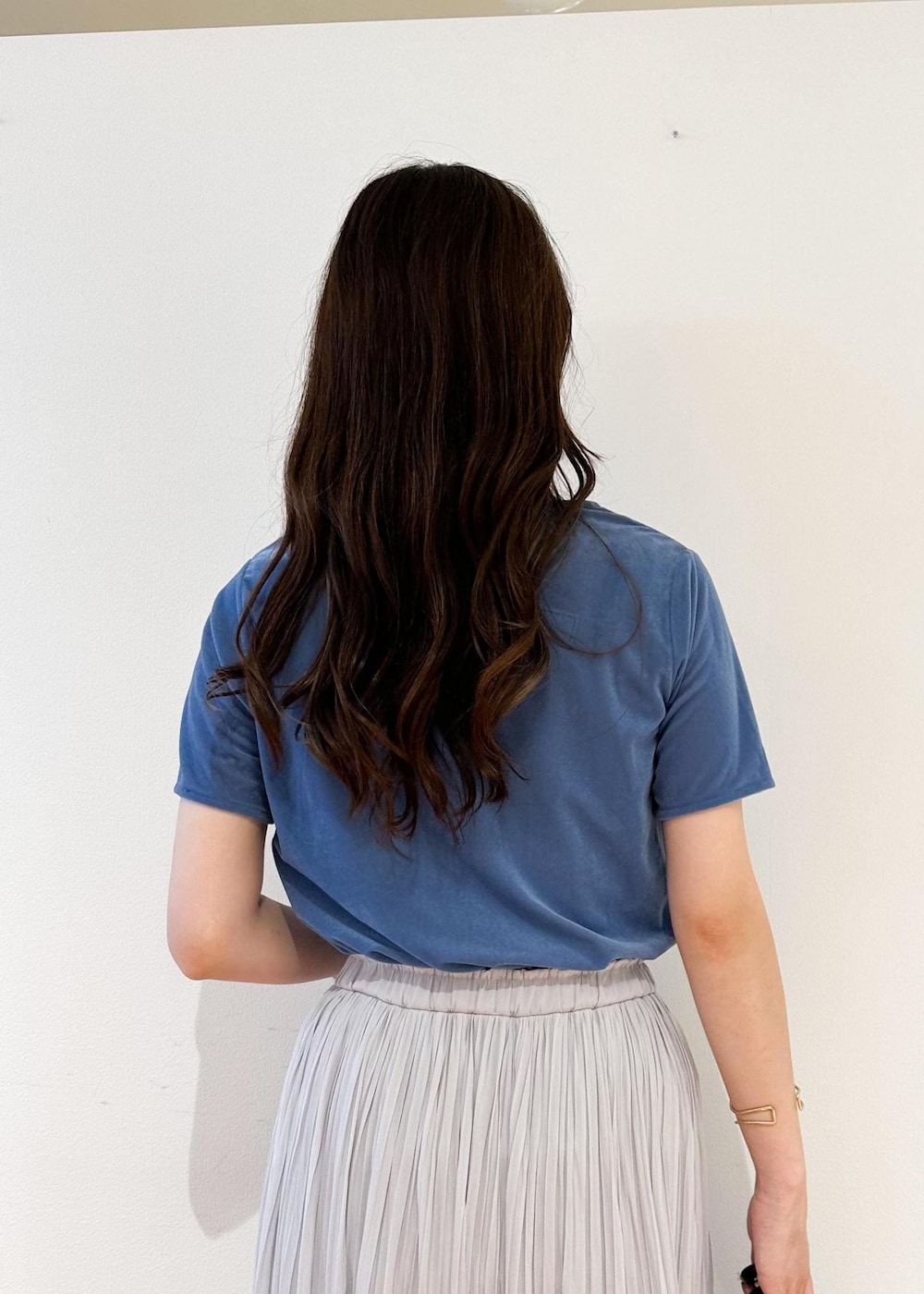 グレー系のスカート、ブラック系のショルダーバッグ、ブルー系のTシャツ/カットソーを着用したレディースの夏コーディネートの5枚目の写真