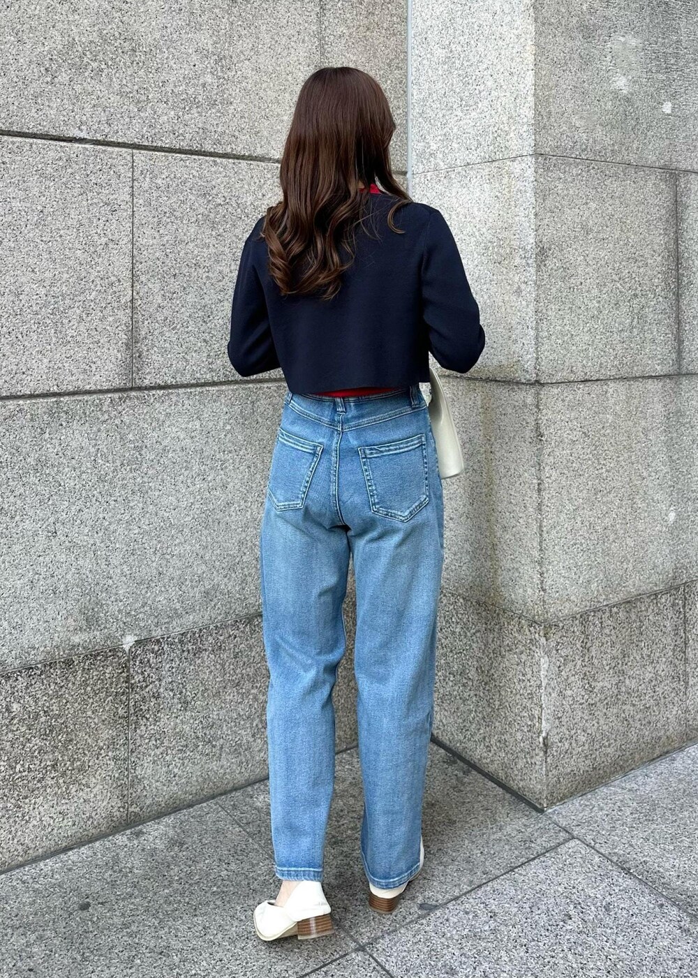 レッド系のニット/セーター、ブルー系のデニムパンツ、ブルー系のカーディガン/ボレロを着用したレディースの冬コーディネートの3枚目の写真