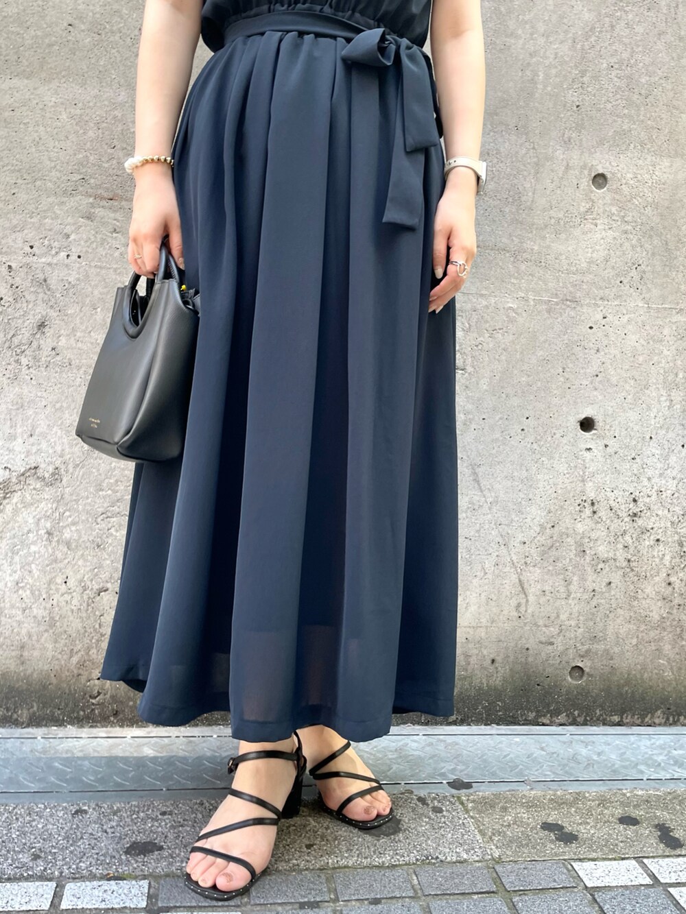 ブルー系のワンピース、ブラック系のショルダーバッグを着用したレディースの夏コーディネートの5枚目の写真