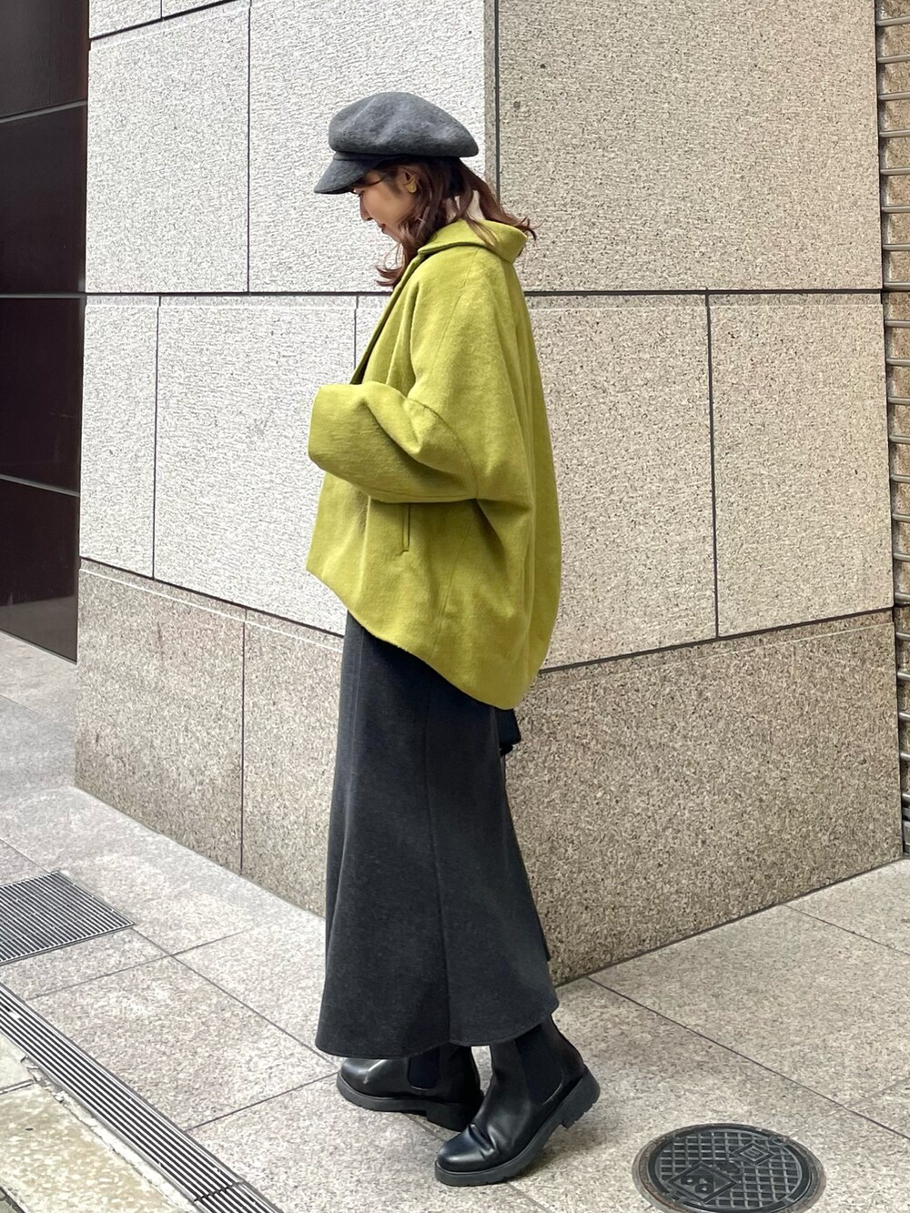 イエロー系のその他アウター、ブラック系のニット/セーター、ブラック系のショルダーバッグを着用したレディースの冬コーディネートの2枚目の写真