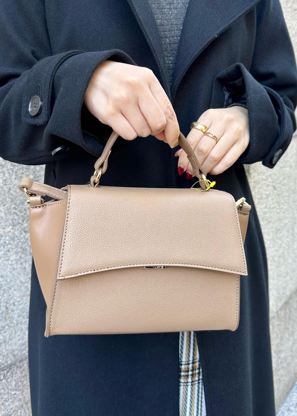 ブラウン系のショルダーバッグ、ブラック系のその他アウター、ホワイト系のスカートを着用したレディースの冬コーディネートの6枚目の写真