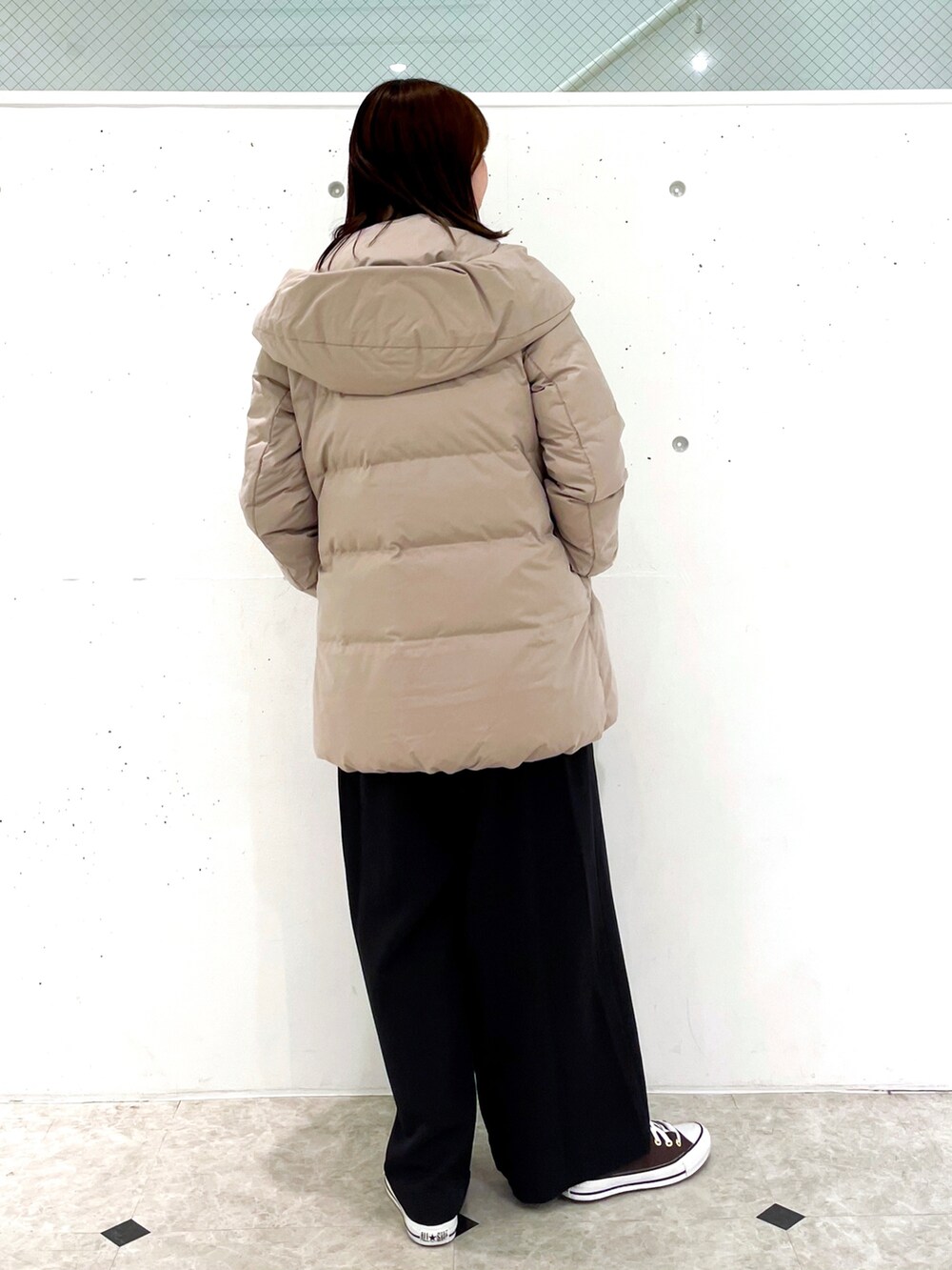 ブラウン系のダウンジャケット/コート、ブラック系のつなぎ/オールインワン、ブラウン系のニット/セーターを着用したレディースの冬コーディネートの2枚目の写真