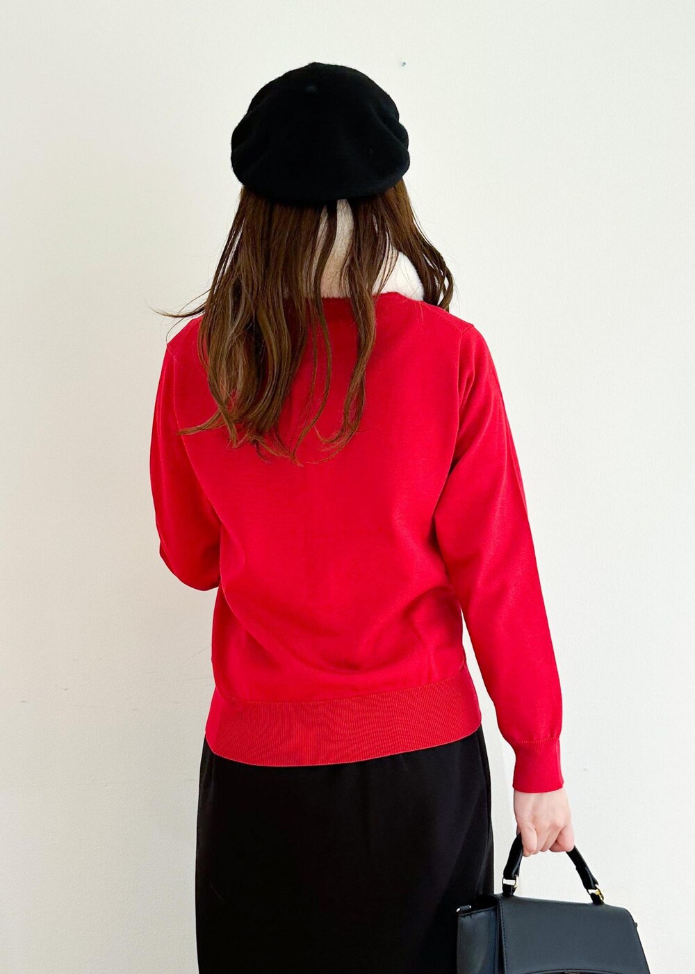 レッド系のカーディガン/ボレロ、ブラック系のショルダーバッグ、ブラック系のスカートを着用したレディースの冬コーディネートの5枚目の写真