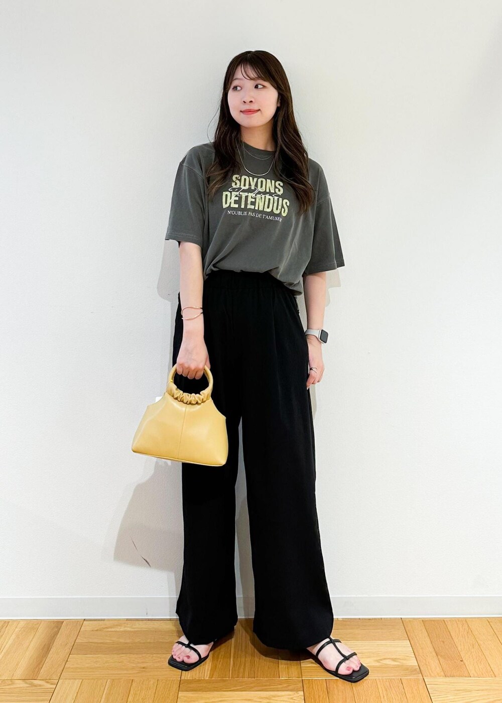 イエロー系のショルダーバッグ、グレー系のTシャツ/カットソー、ブラック系のその他パンツを着用したレディースの秋コーディネートの2枚目の写真