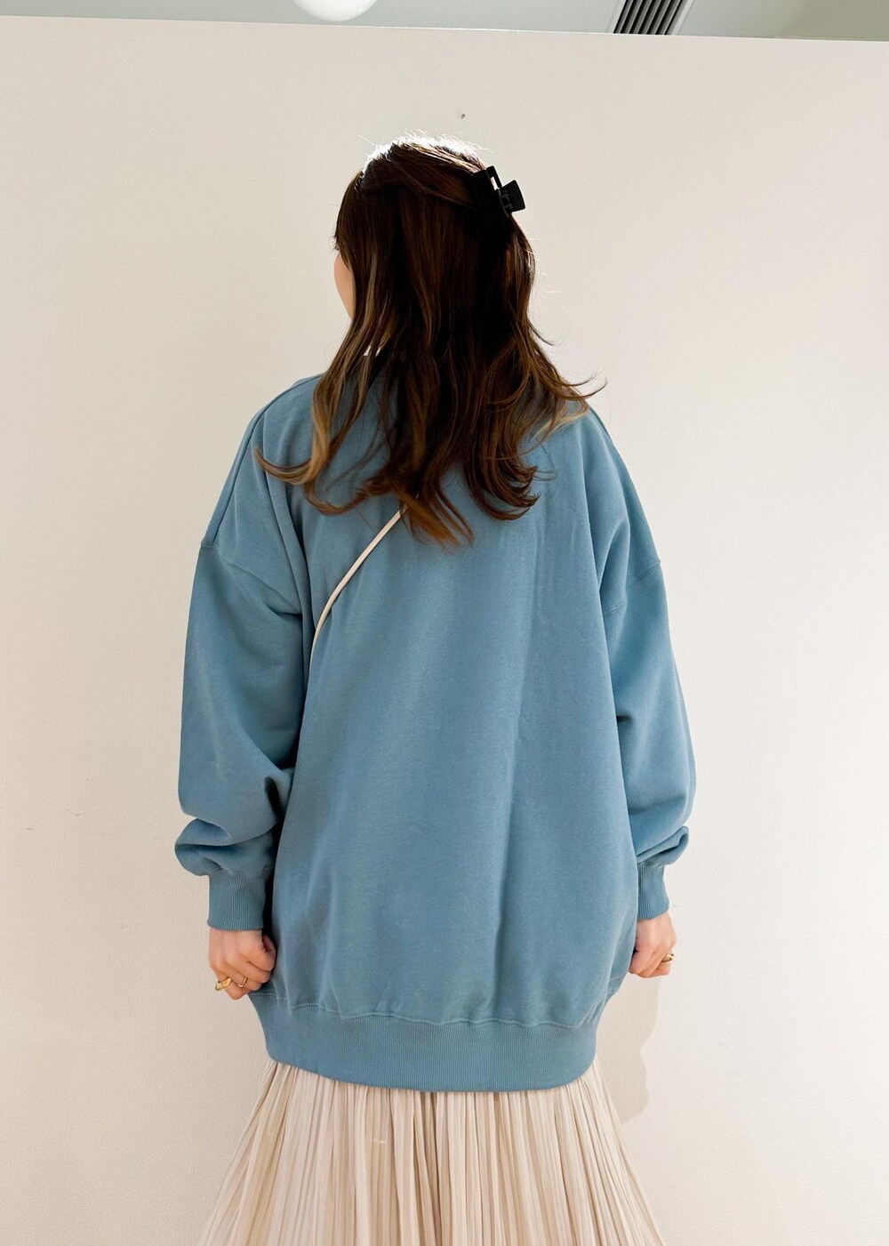 ベージュ系のスカート、ホワイト系のショルダーバッグ、グリーン系のスウェットを着用したレディースの秋コーディネートの5枚目の写真