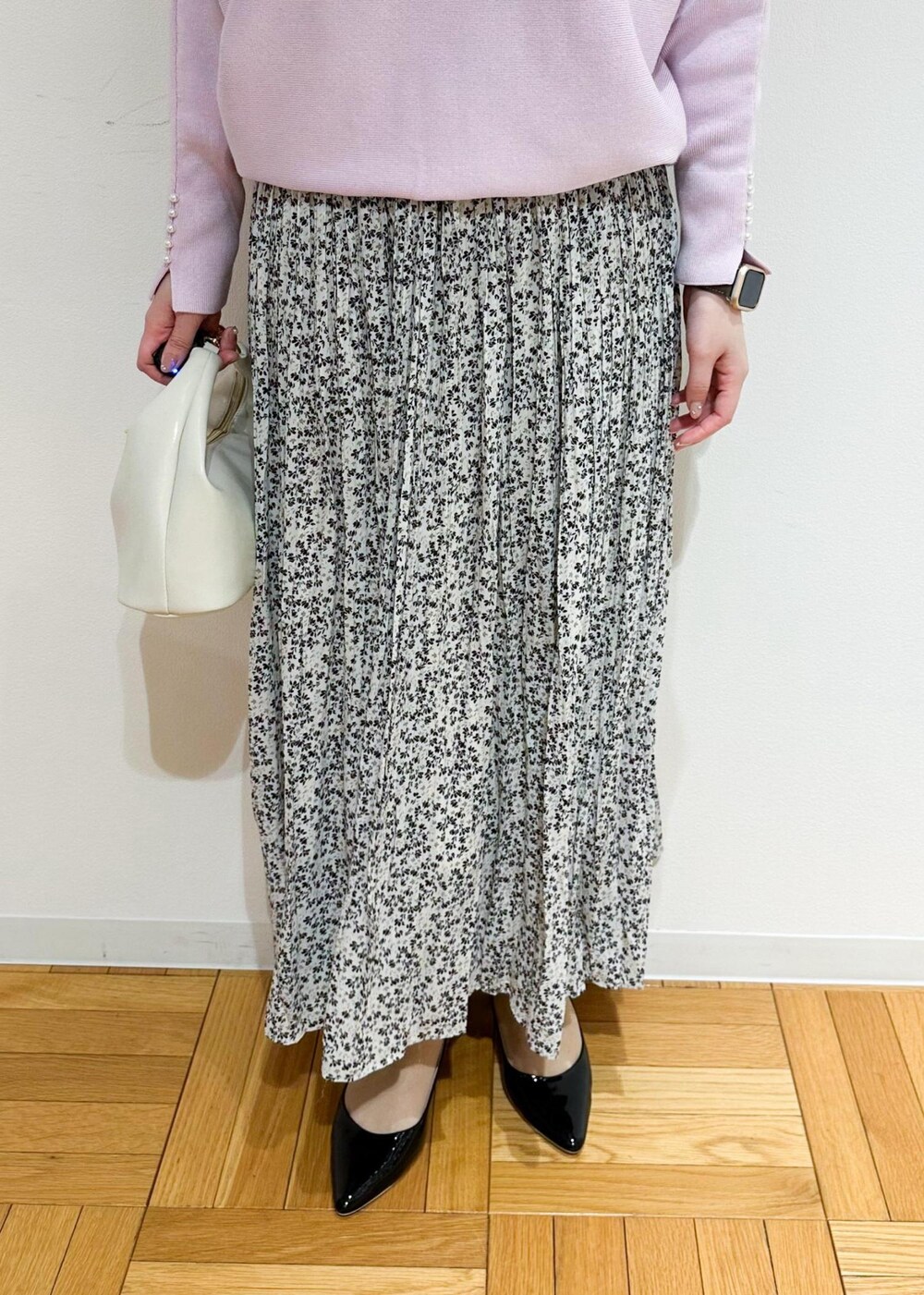 ベージュ系のスカート、ホワイト系のショルダーバッグ、ピンク系のニット/セーターを着用したレディースの冬コーディネートの5枚目の写真