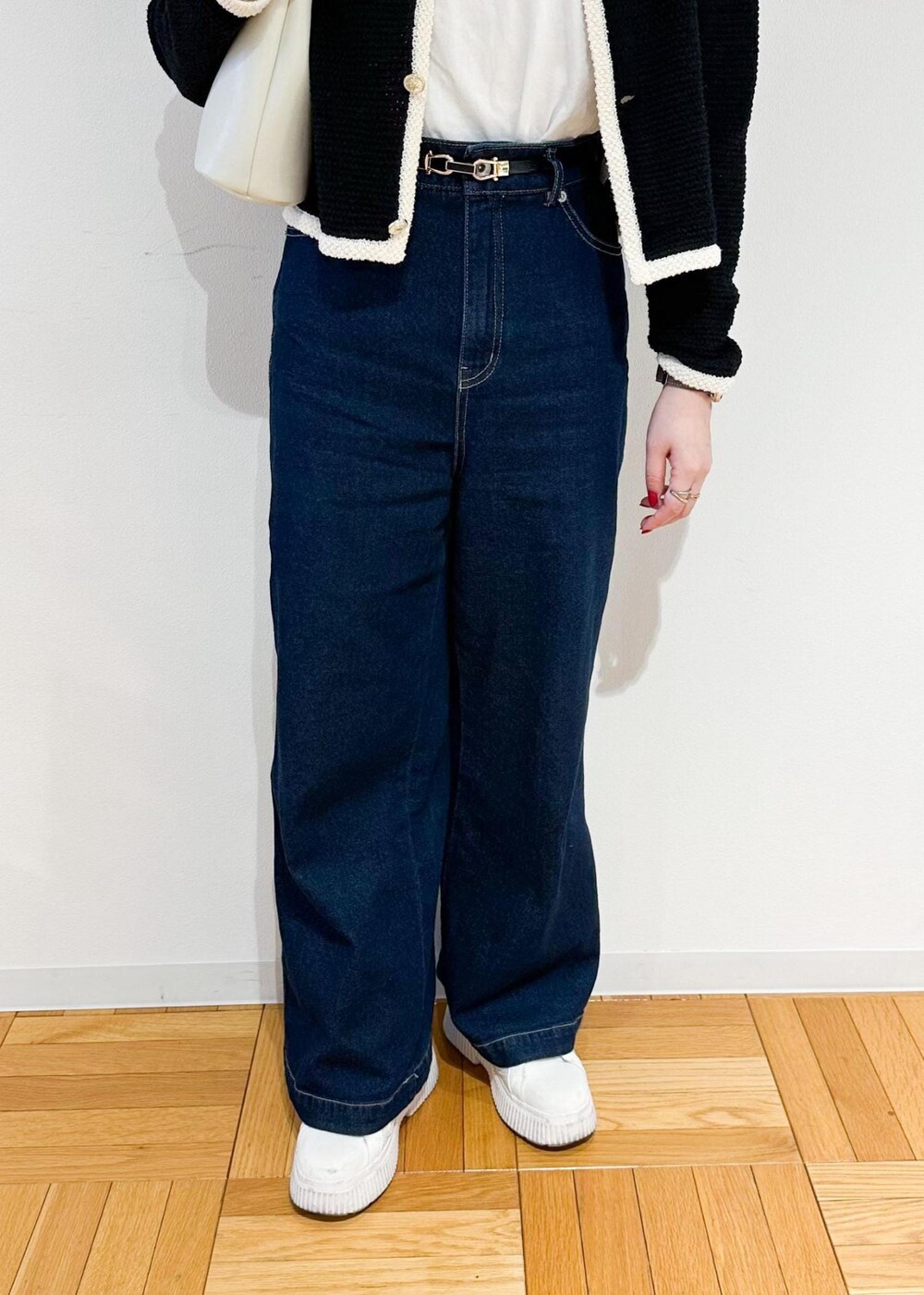 ホワイト系のショルダーバッグ、ブルー系のデニムパンツ、ブラック系のカーディガン/ボレロを着用したレディースの冬コーディネートの6枚目の写真