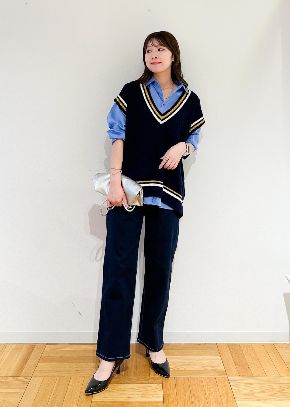 シルバー系のトートバッグ、ブルー系のベスト、ブルー系のシャツ/ブラウスを着用したレディースの夏コーディネートの2枚目の写真