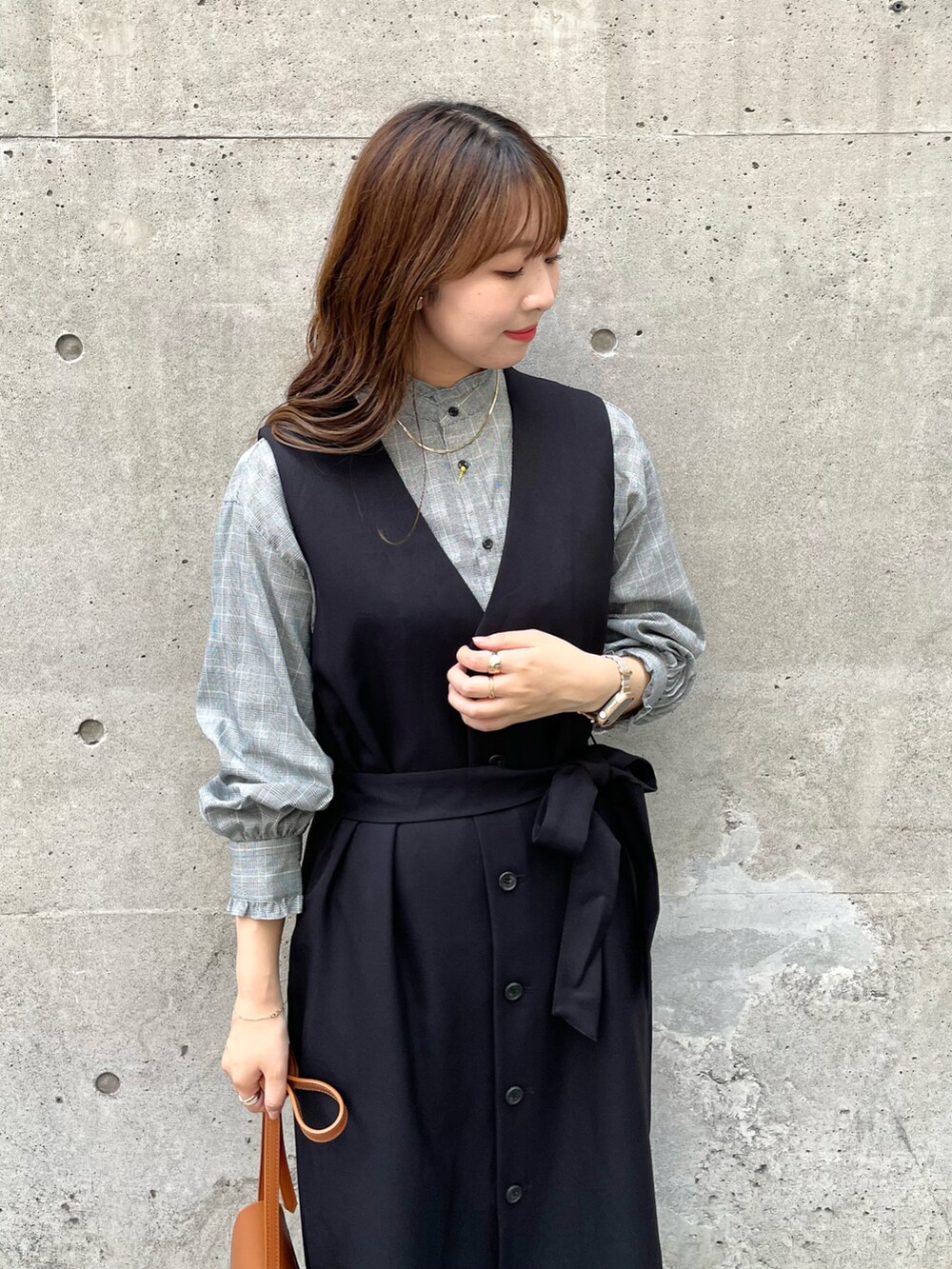 ブラック系のジャンパースカート、ブラック系のシャツ/ブラウス、ブラウン系のショルダーバッグを着用したレディースの秋コーディネートの3枚目の写真